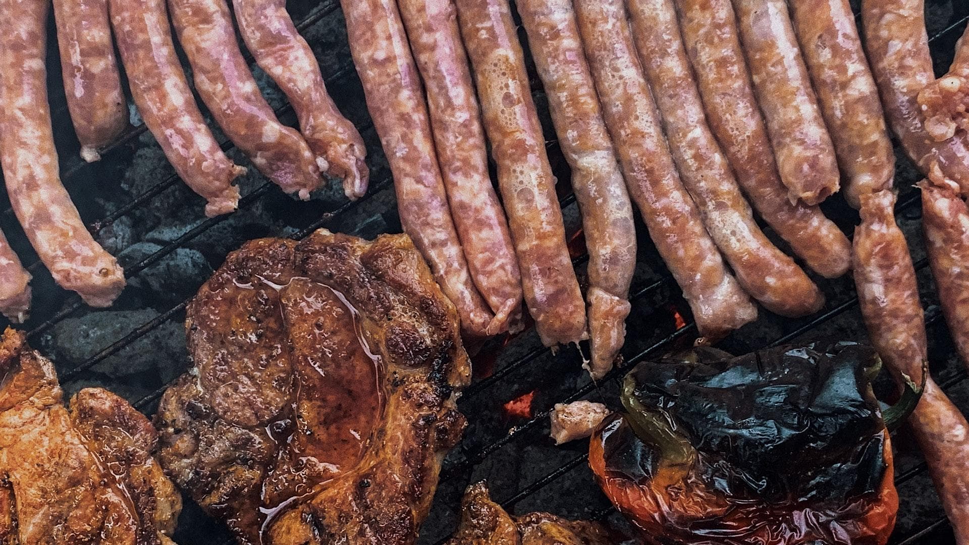 Würstchen, Fleisch und Paprika auf dem Grill.