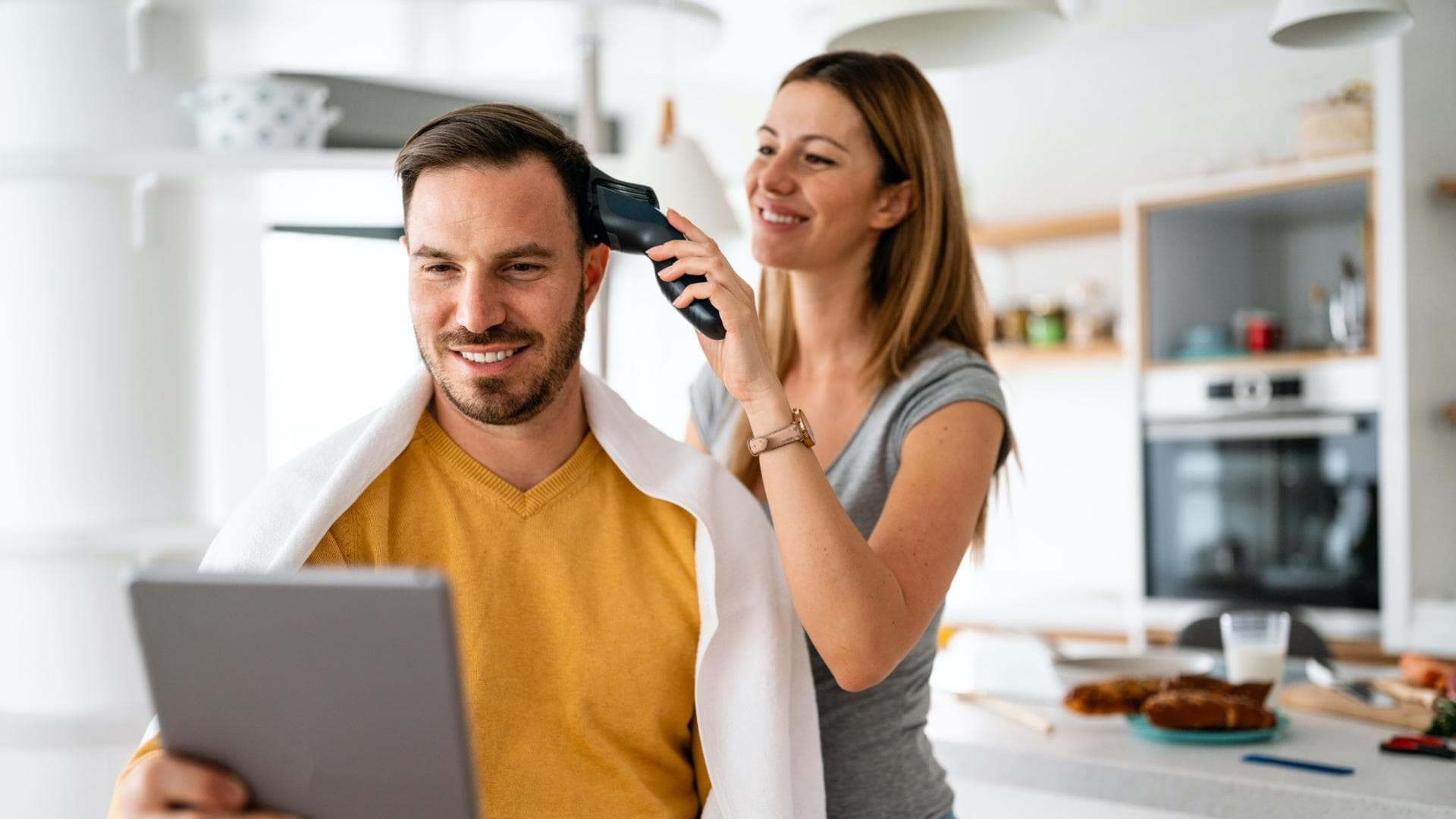 Frau schneidet Mann die Haare