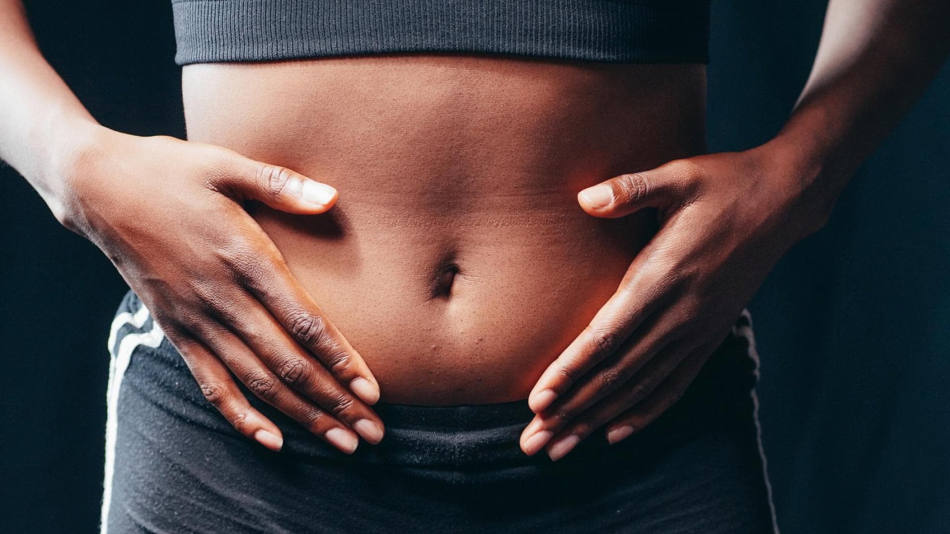 Frau legt Hände auf Ihren Bauch