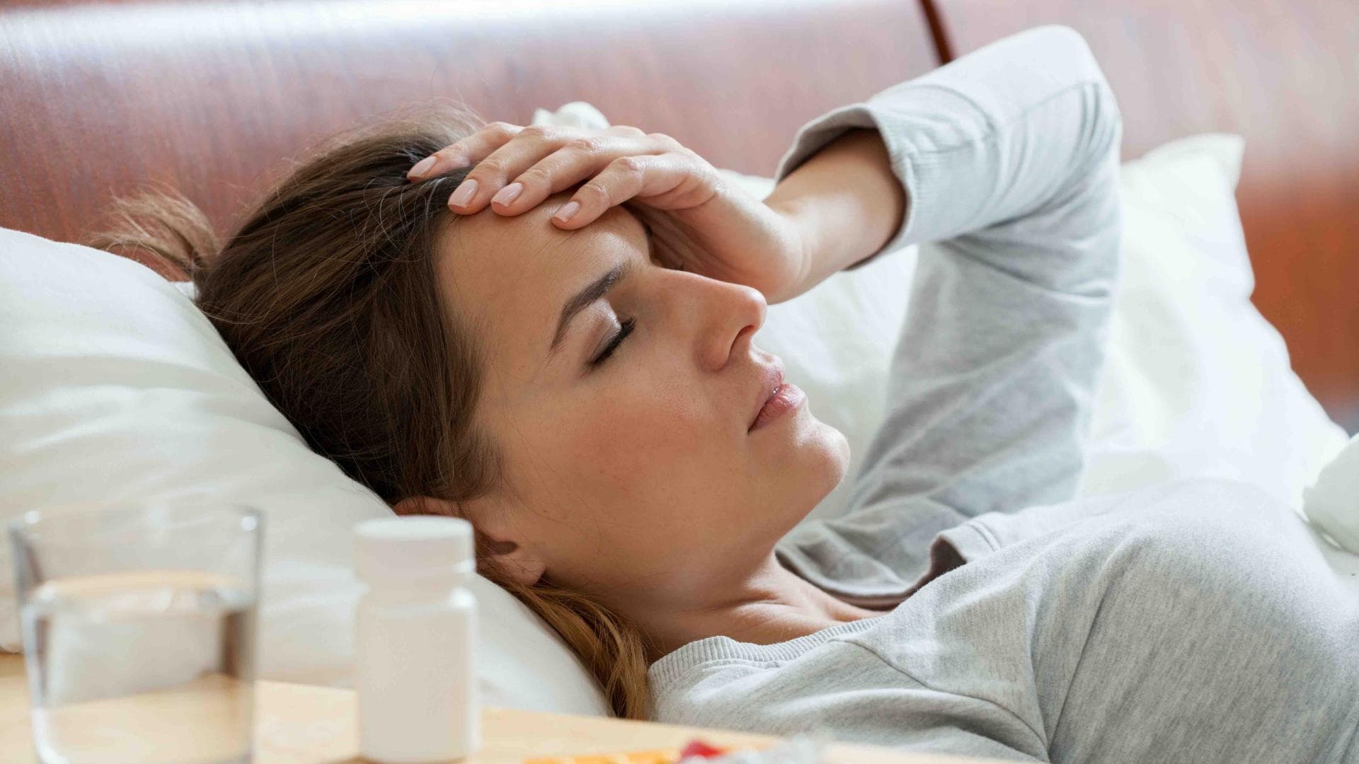 Frau liegt krank im Bett
