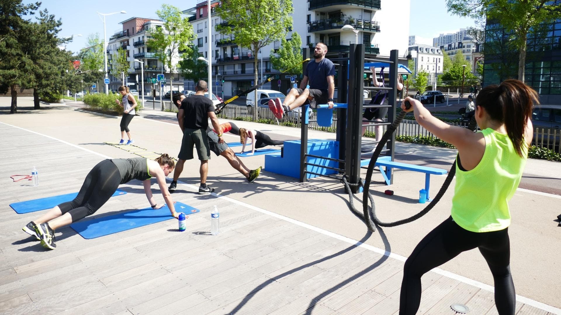 Menschen trainieren draußen mit Fitnessgeräten