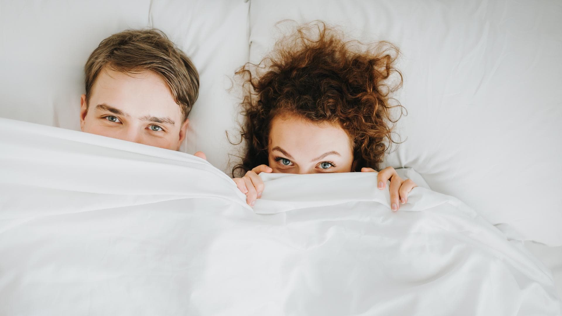 Paar liegt zusammen im Bett