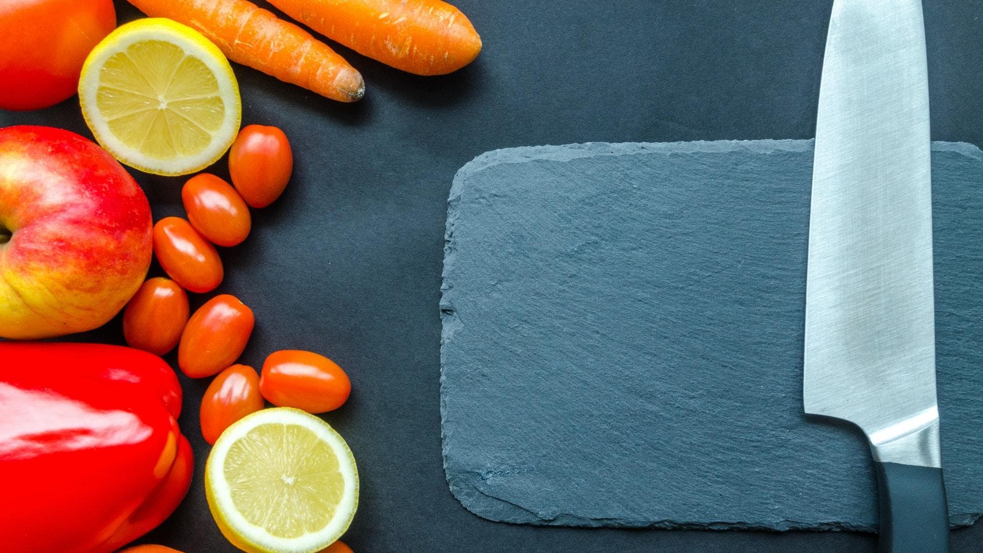 Rohkost neben einem Schneidebrett mit Messer