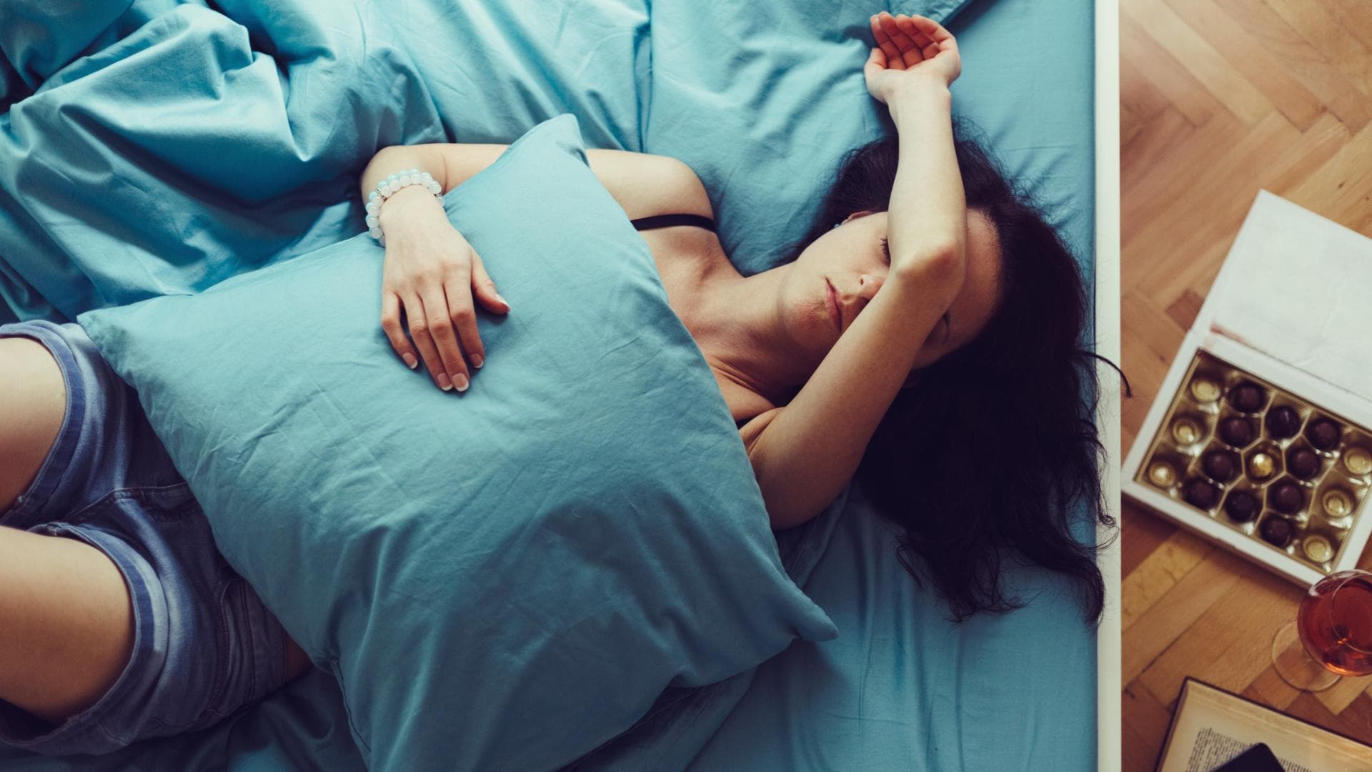 Frau liegt im Bett mit Kopfschmerzen