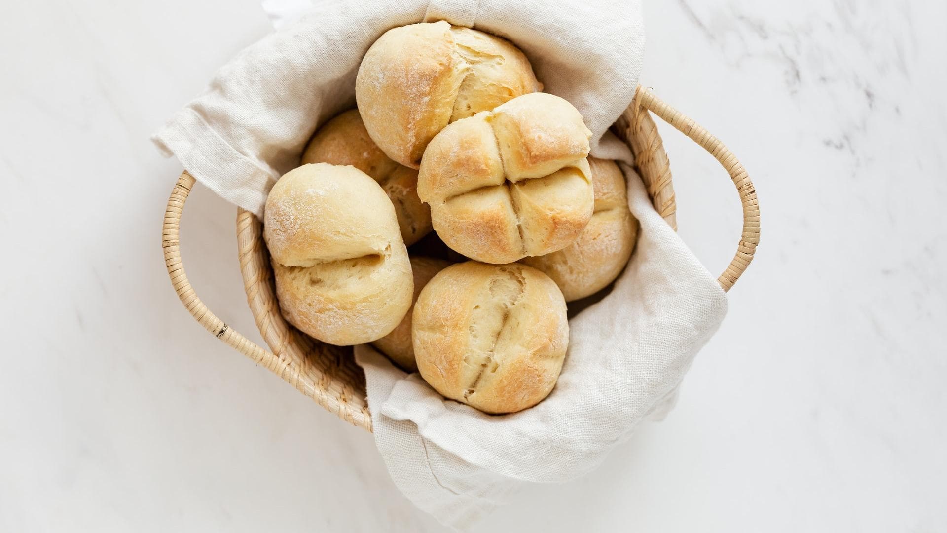 Fluffig und lecker, aber der Nährwert ist gering Weiße Brötchen in einem Korb