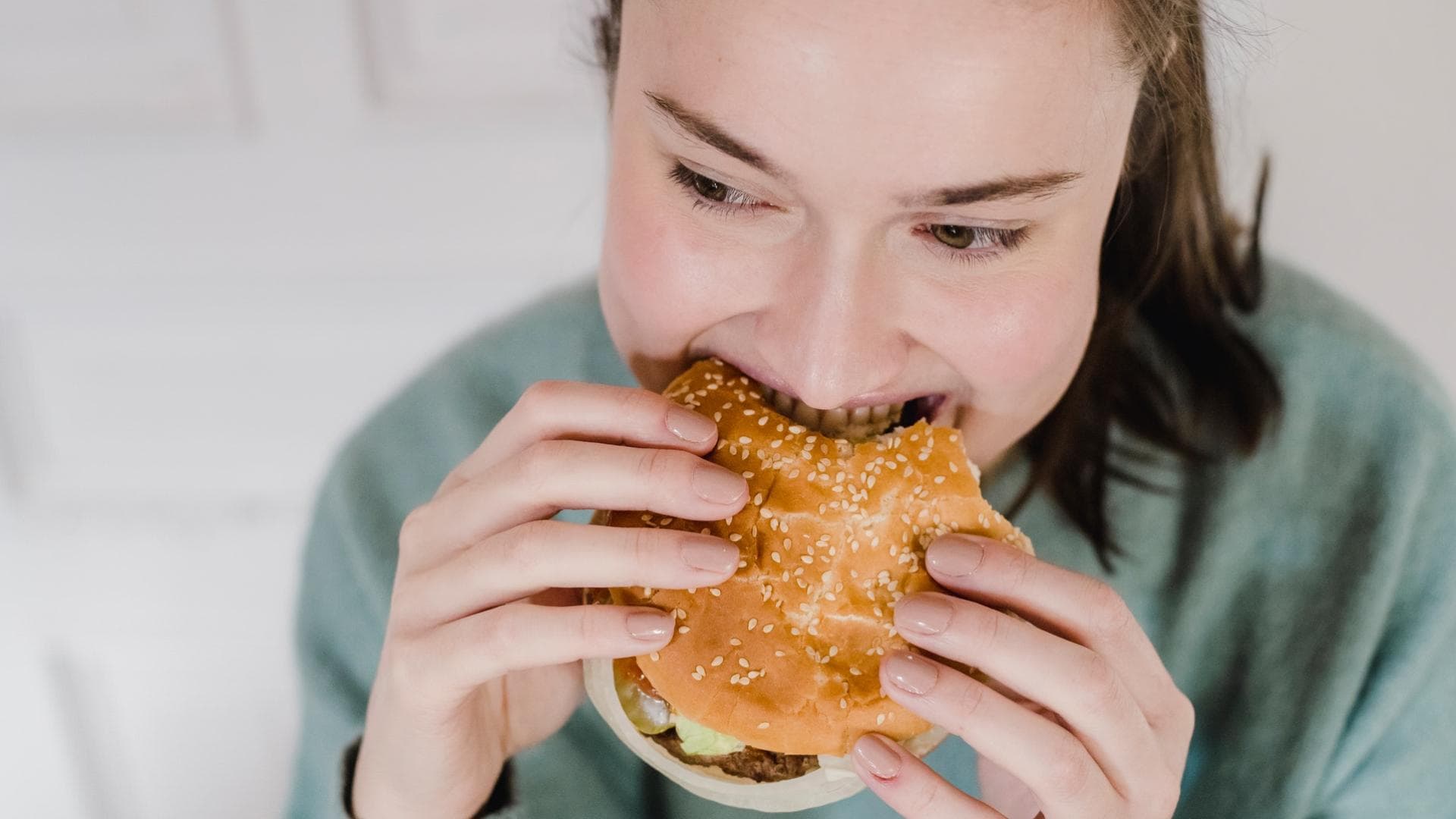 Frau isst Hamburger Frau isst Hamburger