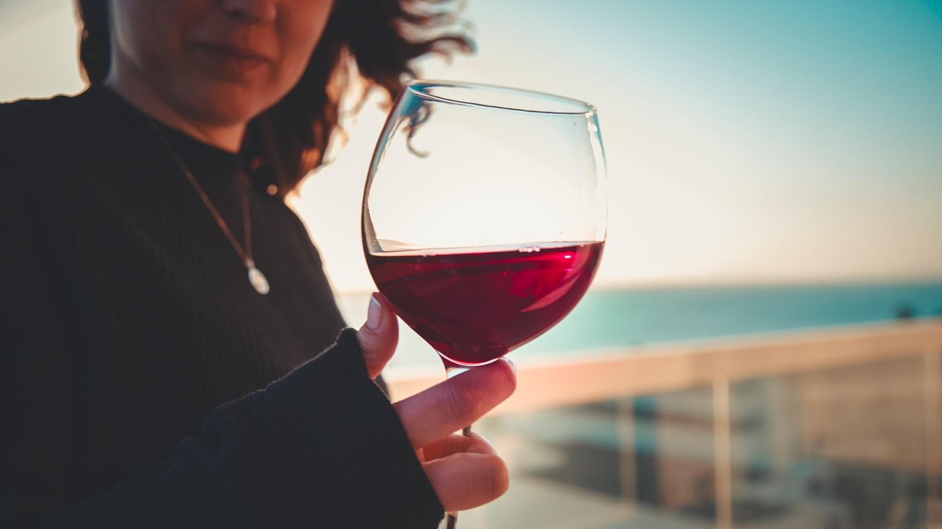 Frau hält ein Glas Rotwein in der Hand