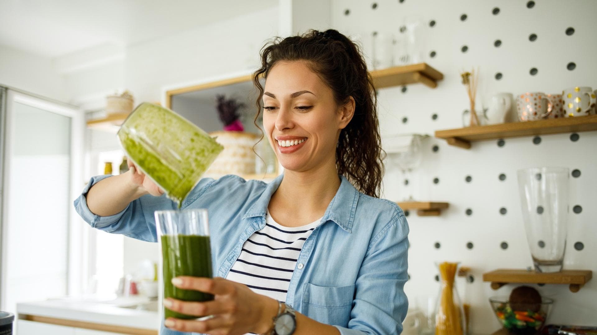 Frau bereitet Smoothie zu Frau bereitet Smoothie zu