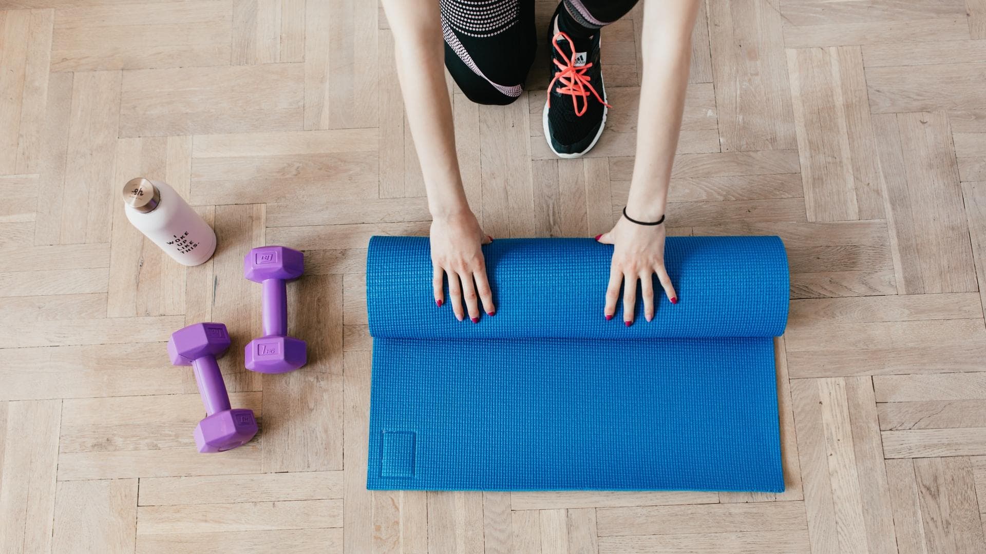 Frau rollt ihre Yogamatte zusammen