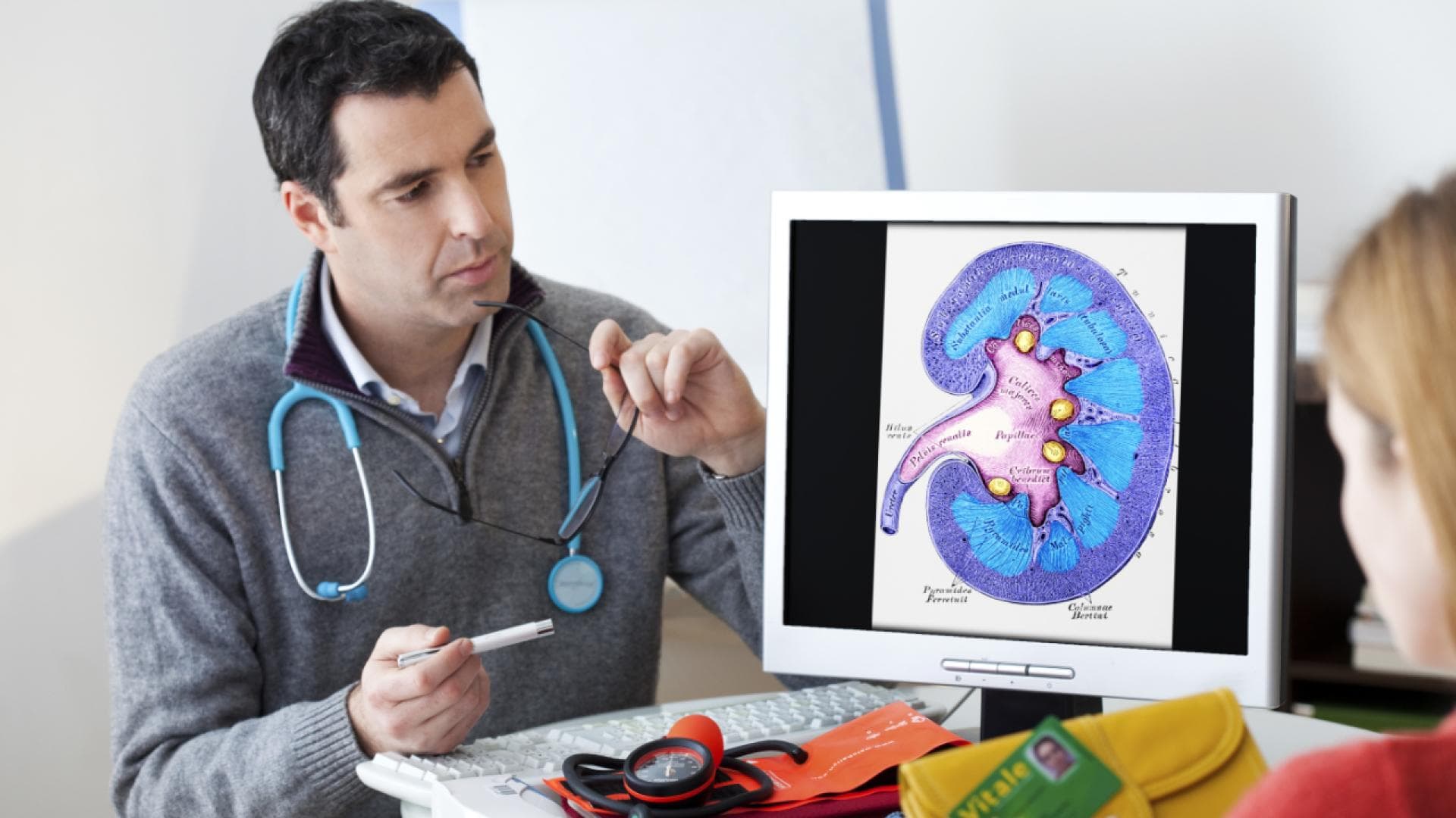 Arzt und Patientin betrachten die Grafik einer Niere