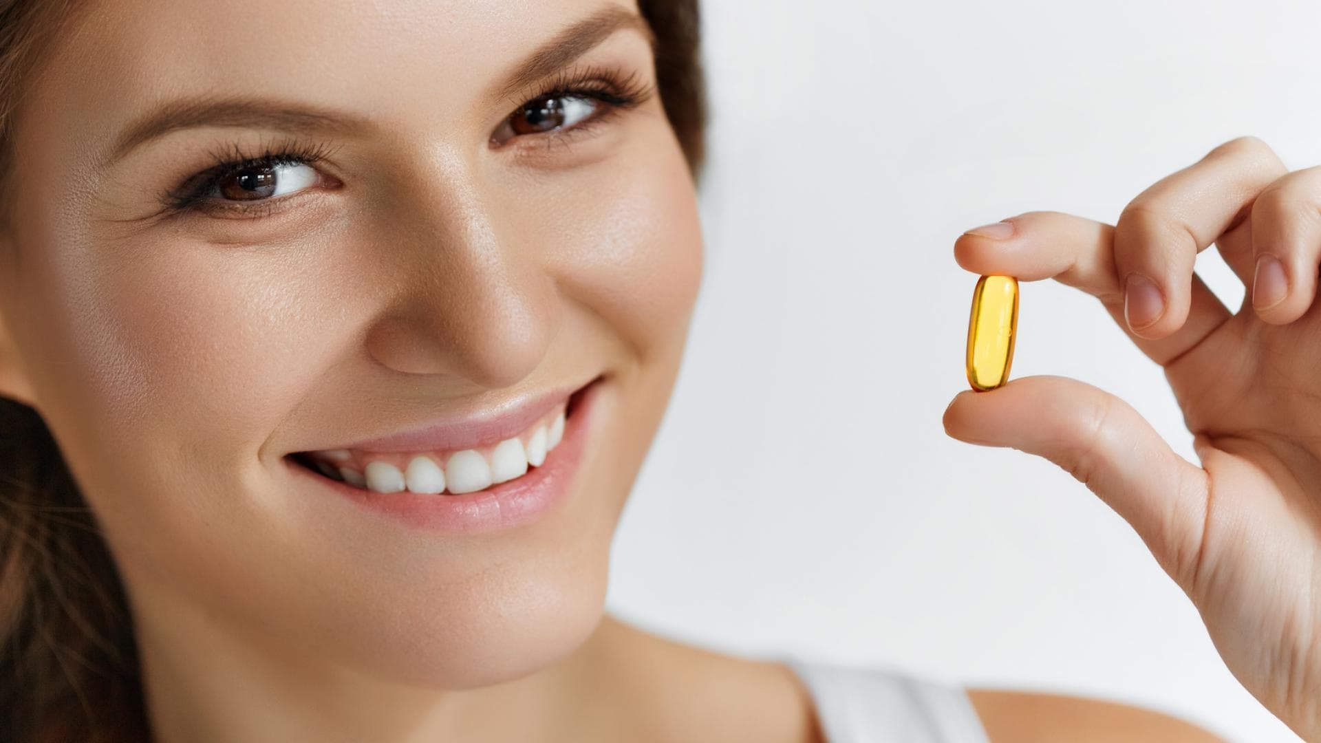 Frau hält Vitamin-Tablette in der Hand