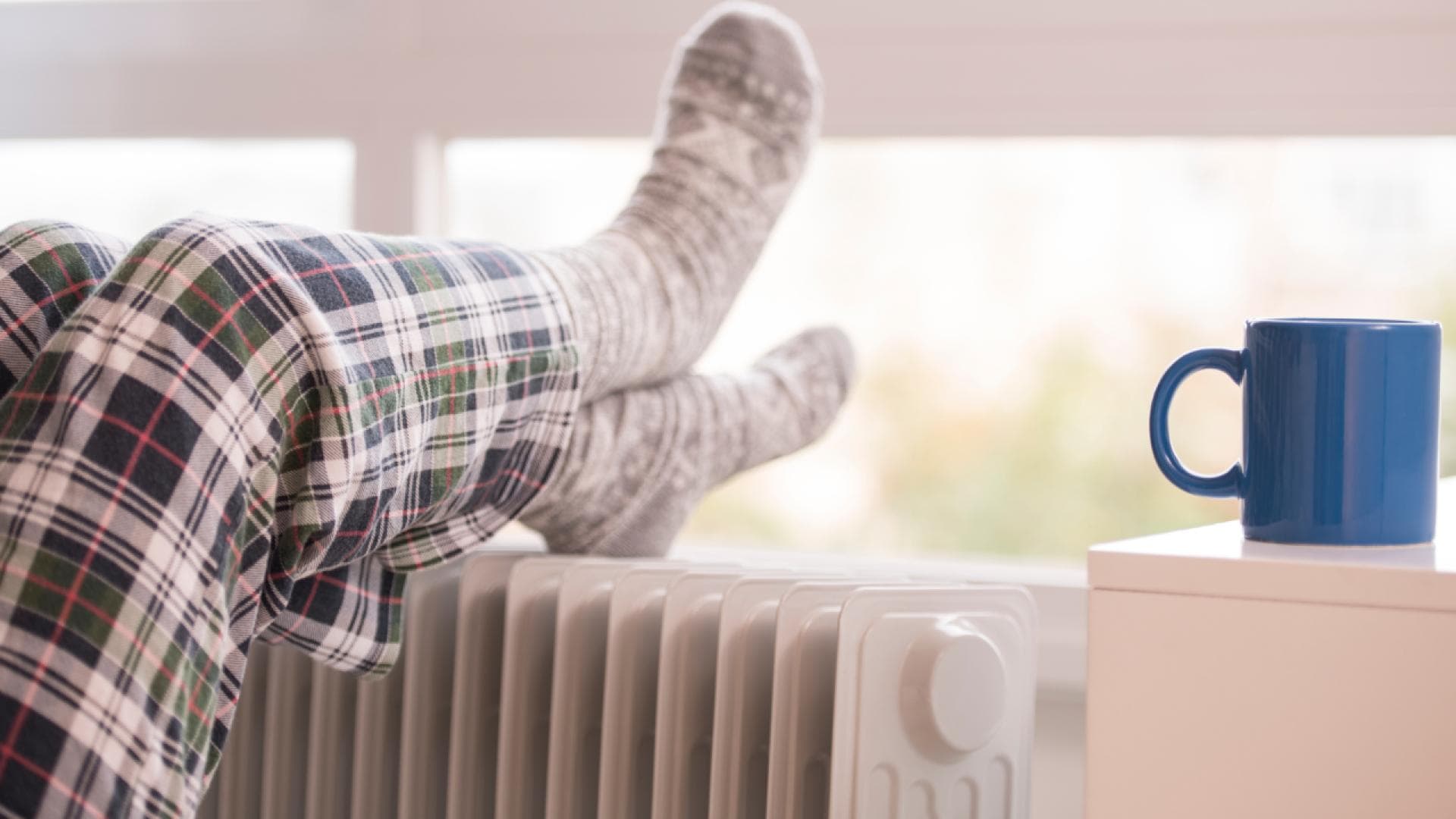 Füße in Wollsocken auf einer Heizung