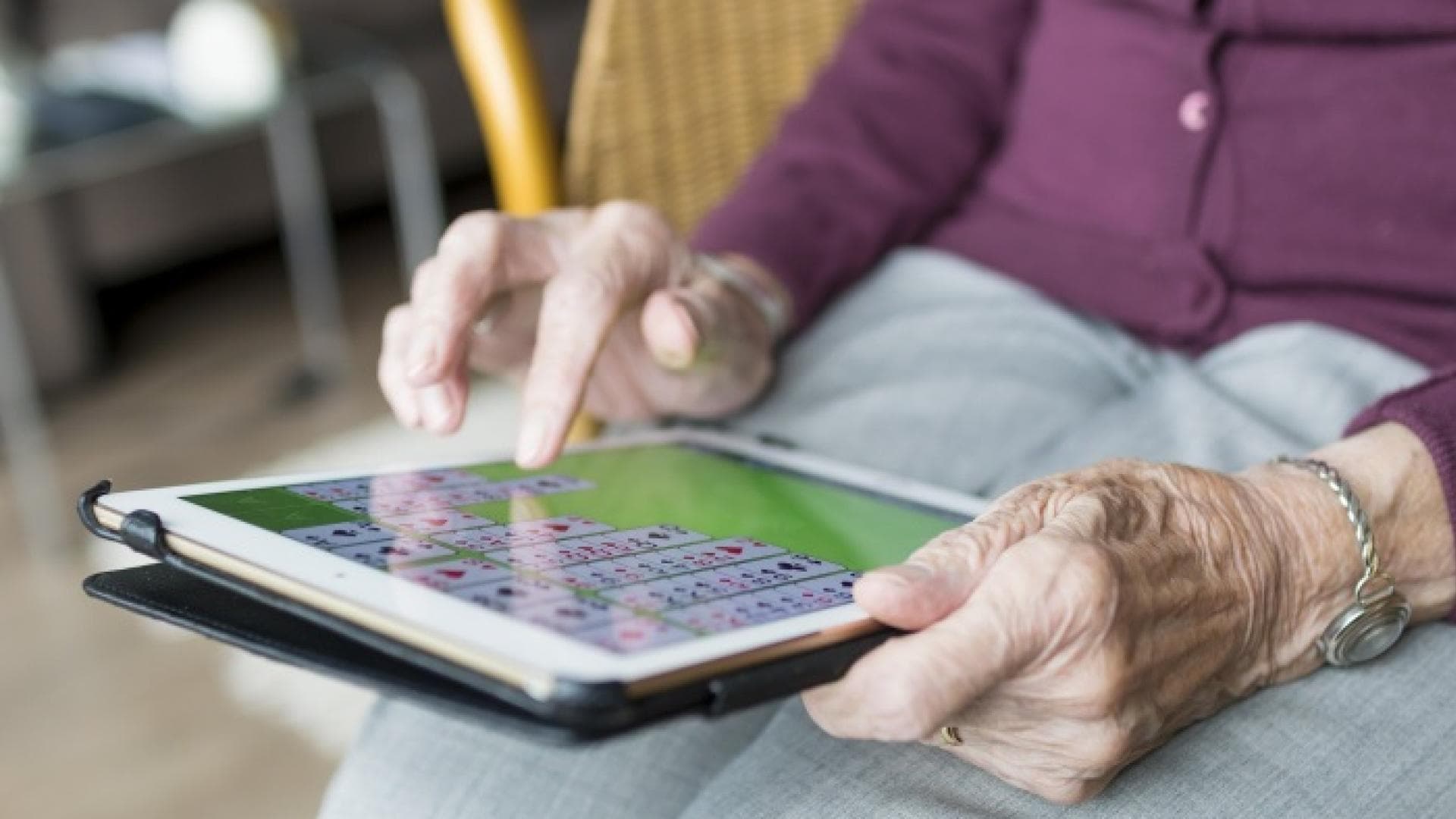 Ältere Frau tippt auf Tablet