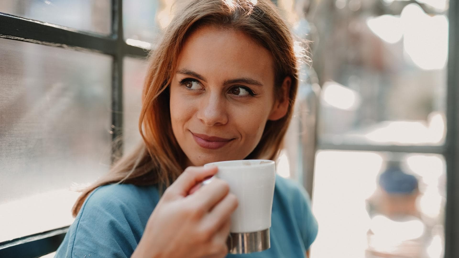 Kaffee macht - gut dosiert -munter. Frau trinkt aus einer Kaffeetasse
