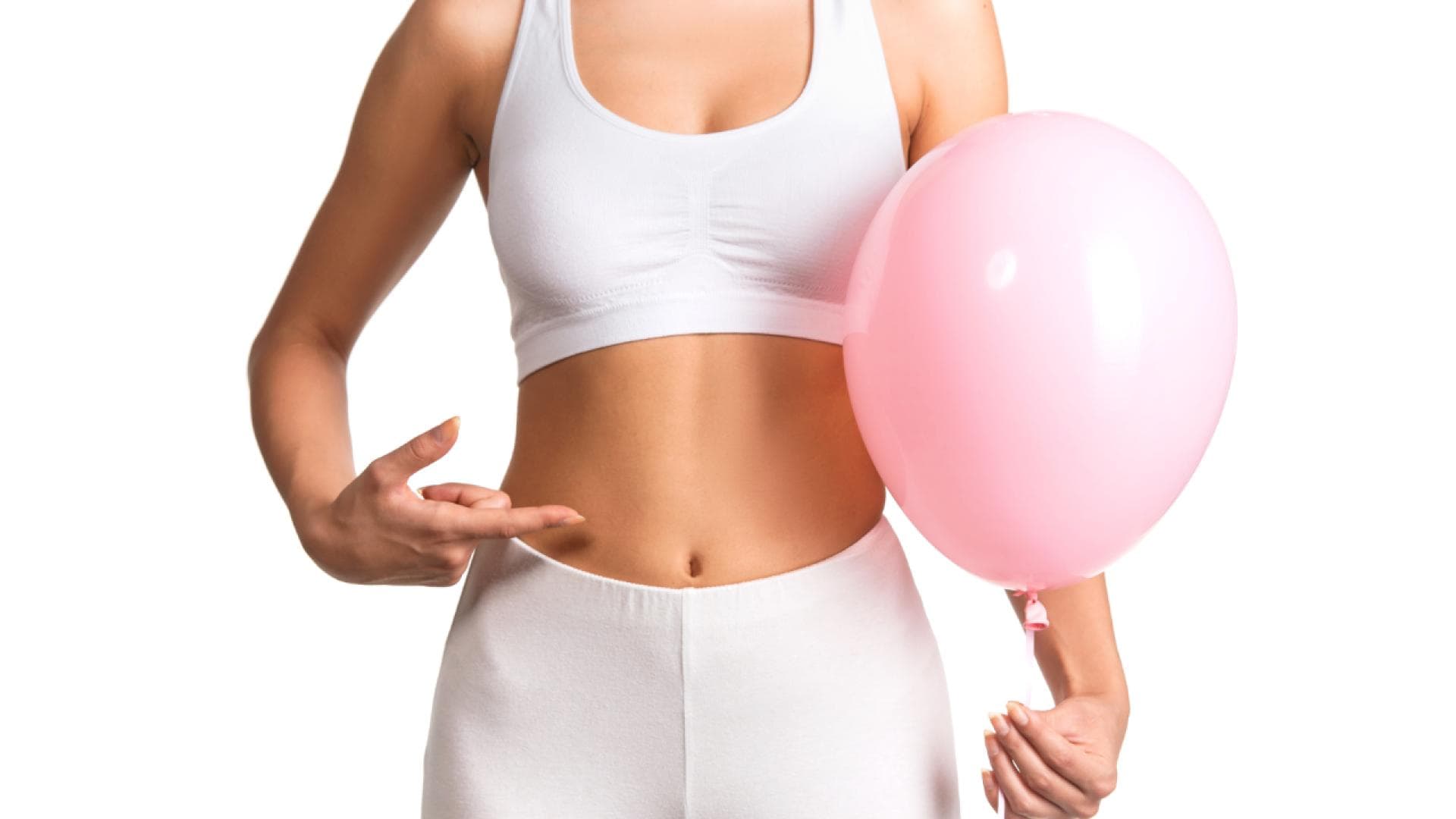 Frau mit Luftballon in der Hand zeigt auf ihren Bauch