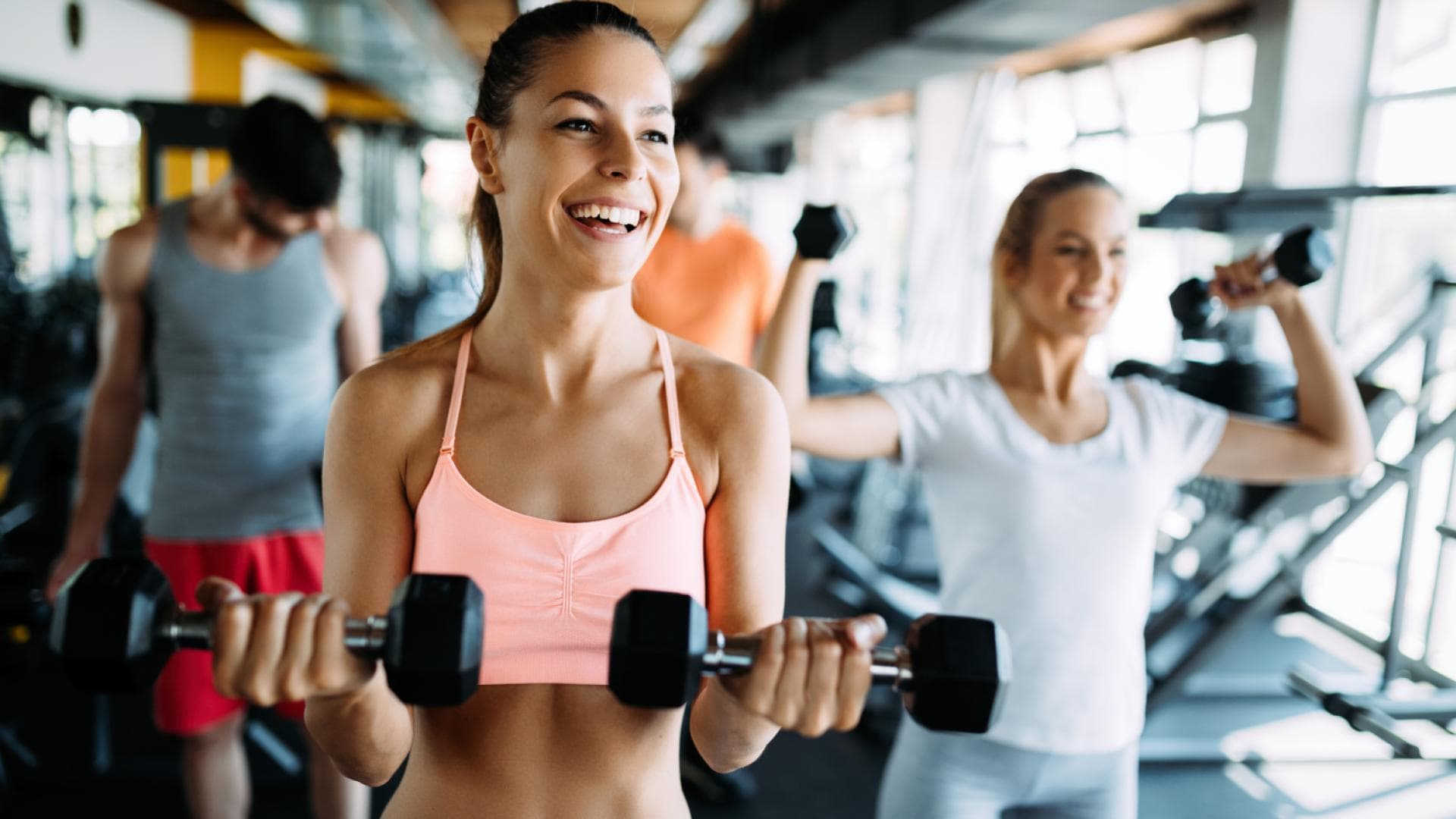 Gruppe trainiert mit Hanteln im Fitnessstudio