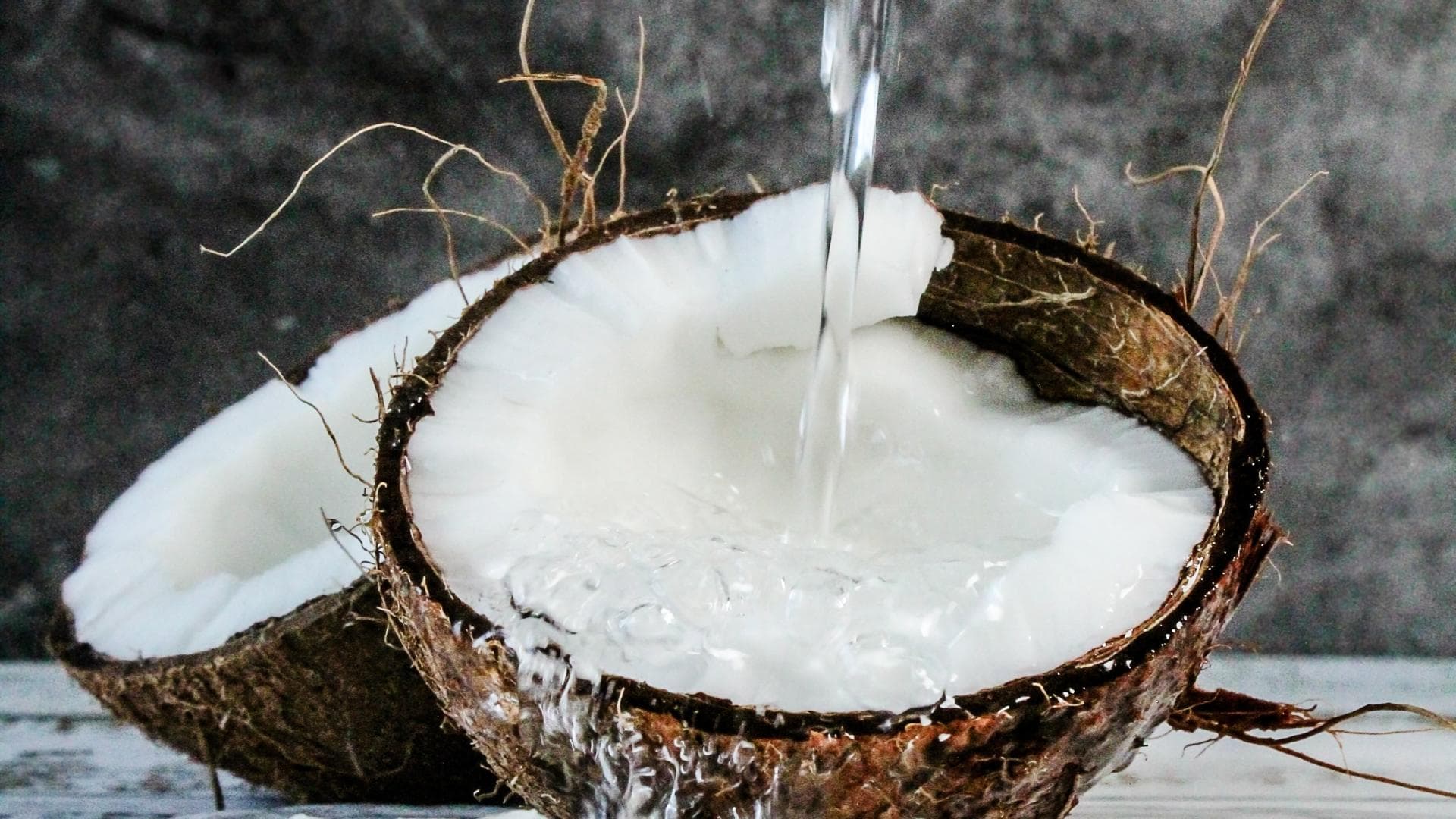 Reife Kokosnuss mit Fruchtfleisch und Wasser