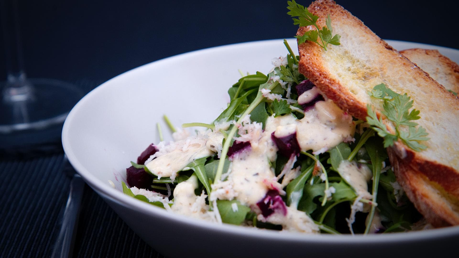 Nahaufnahme Salat mit geröstetem Brot und cremigem Dressing