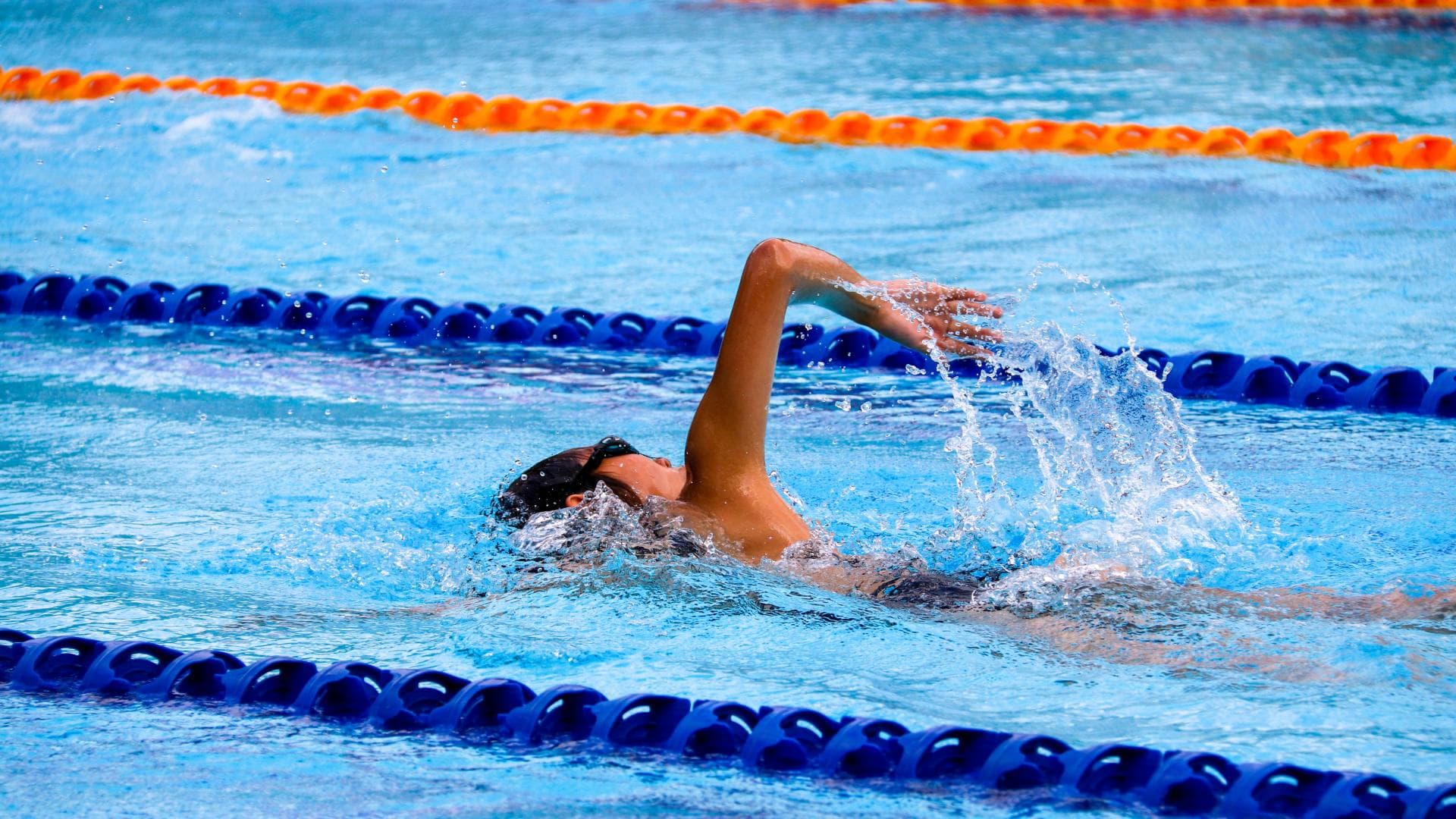 Person schwimmt im Schwimmbad
