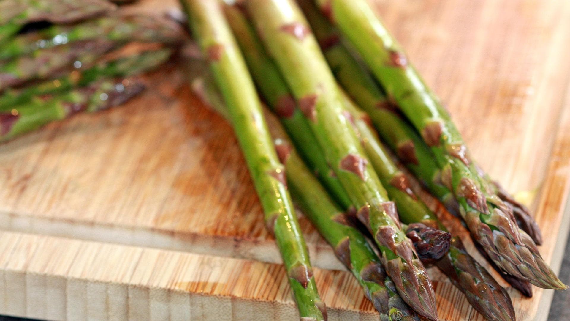 gekochter grüner Spargel auf Holzbrett