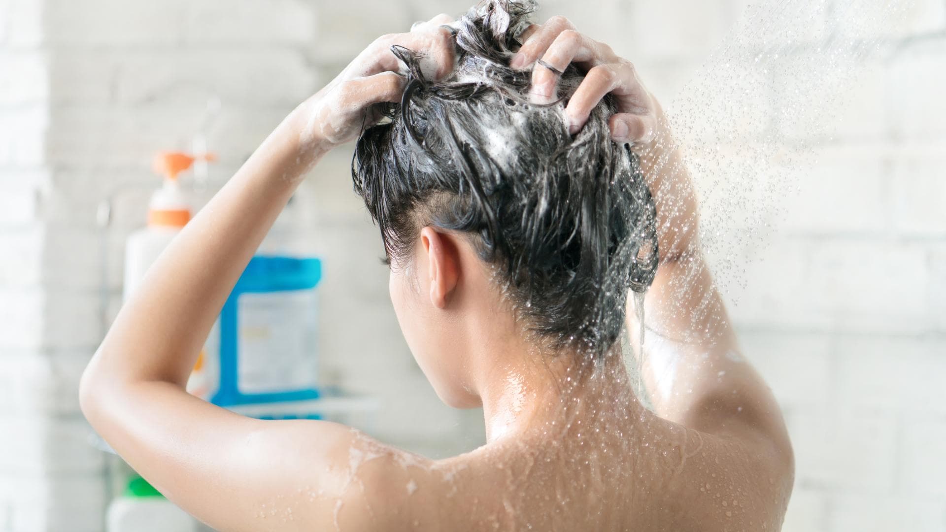 Frau wäscht ihre Haare mit Shampoo