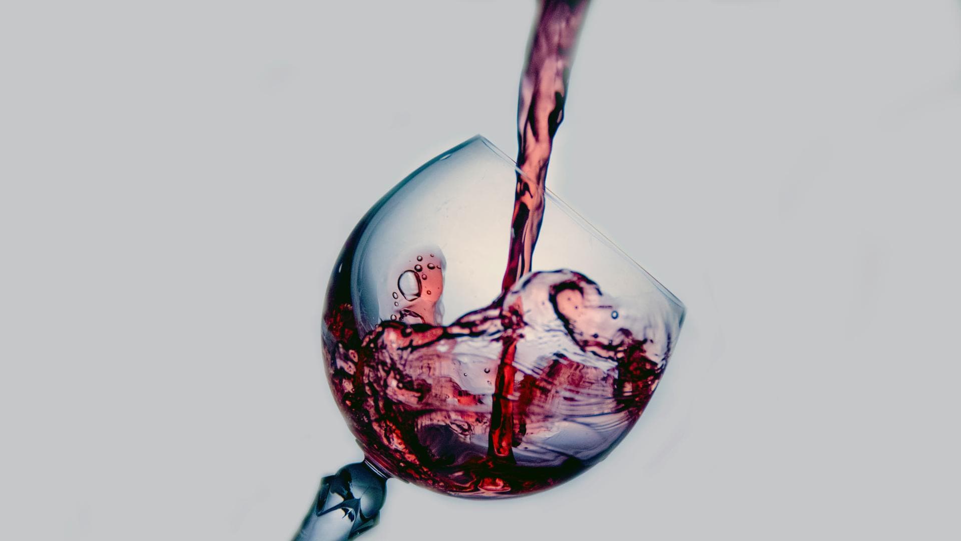 Weinglas wird mit Rotwein befüllt