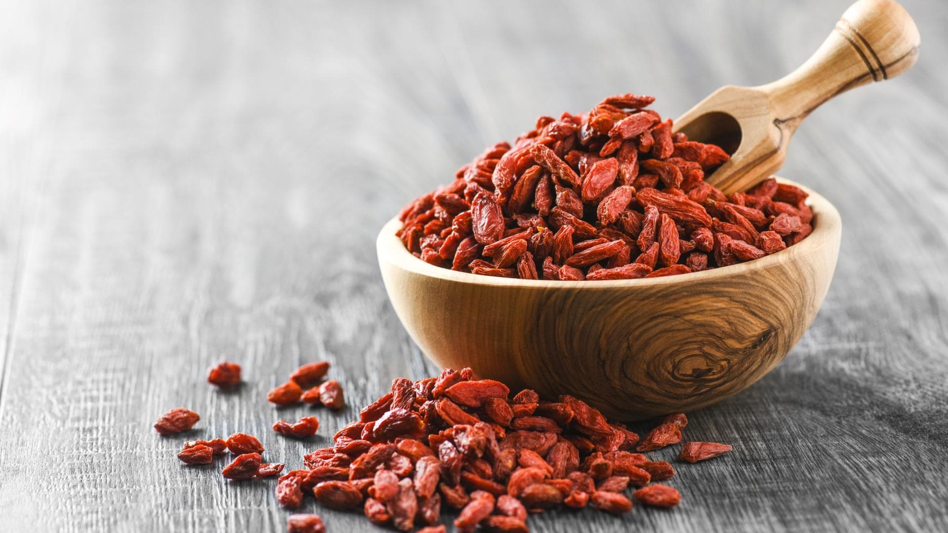 Goji-Beeren in Holzschale auf rustikalem Tisch