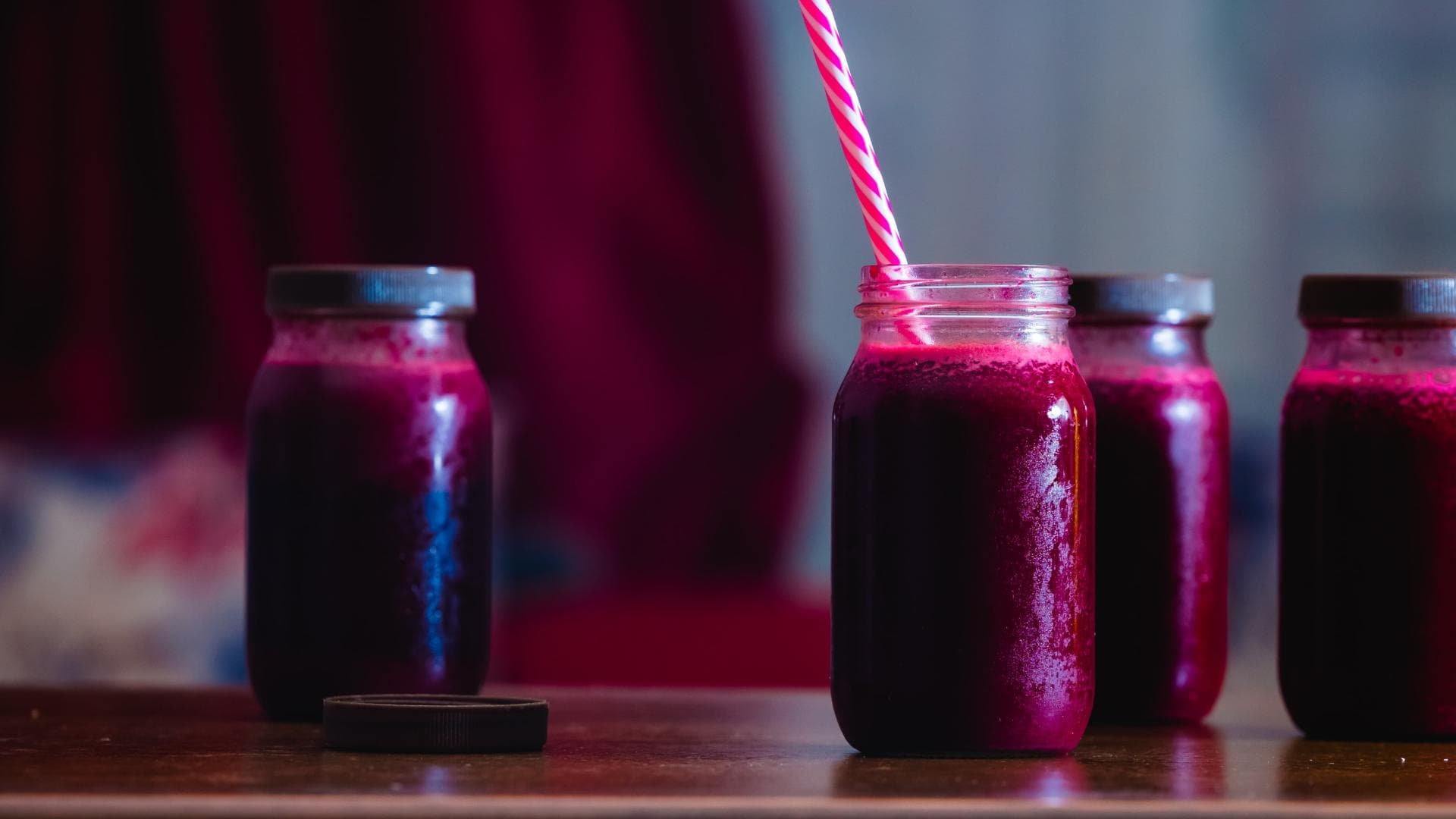 Rote-Beete-Saft in Einmachgläsern mit Strohhalm