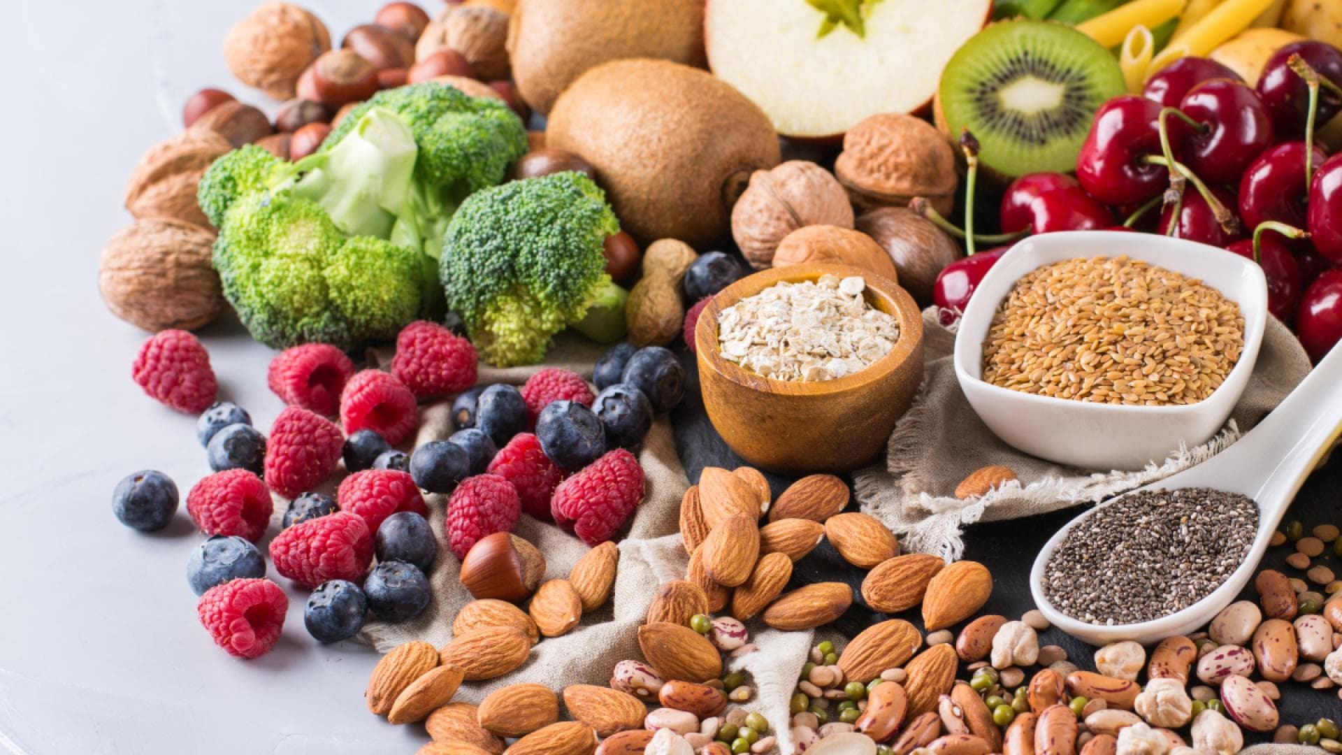 Verschiedene pflanzliche Lebensmittel wie Obst, Gemüse, Nüsse und Samen