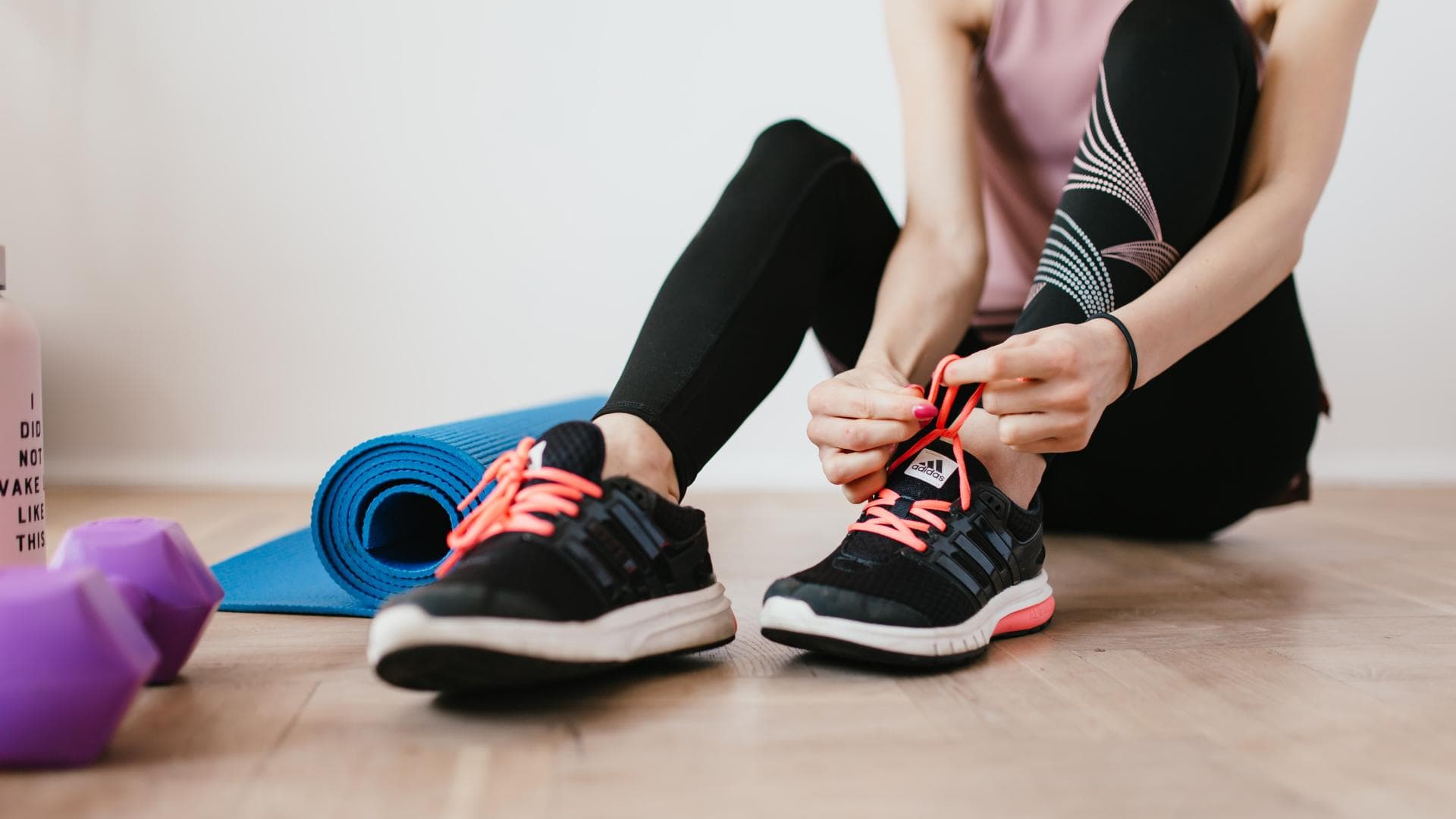 Frau bindet Sportschuhe zu