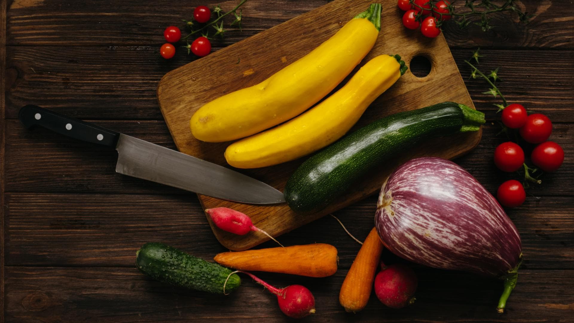 Gelbe Zucchini sind gesund Gelbe Zucchini auf Schneidebrett mit anderen Gemüsesorten