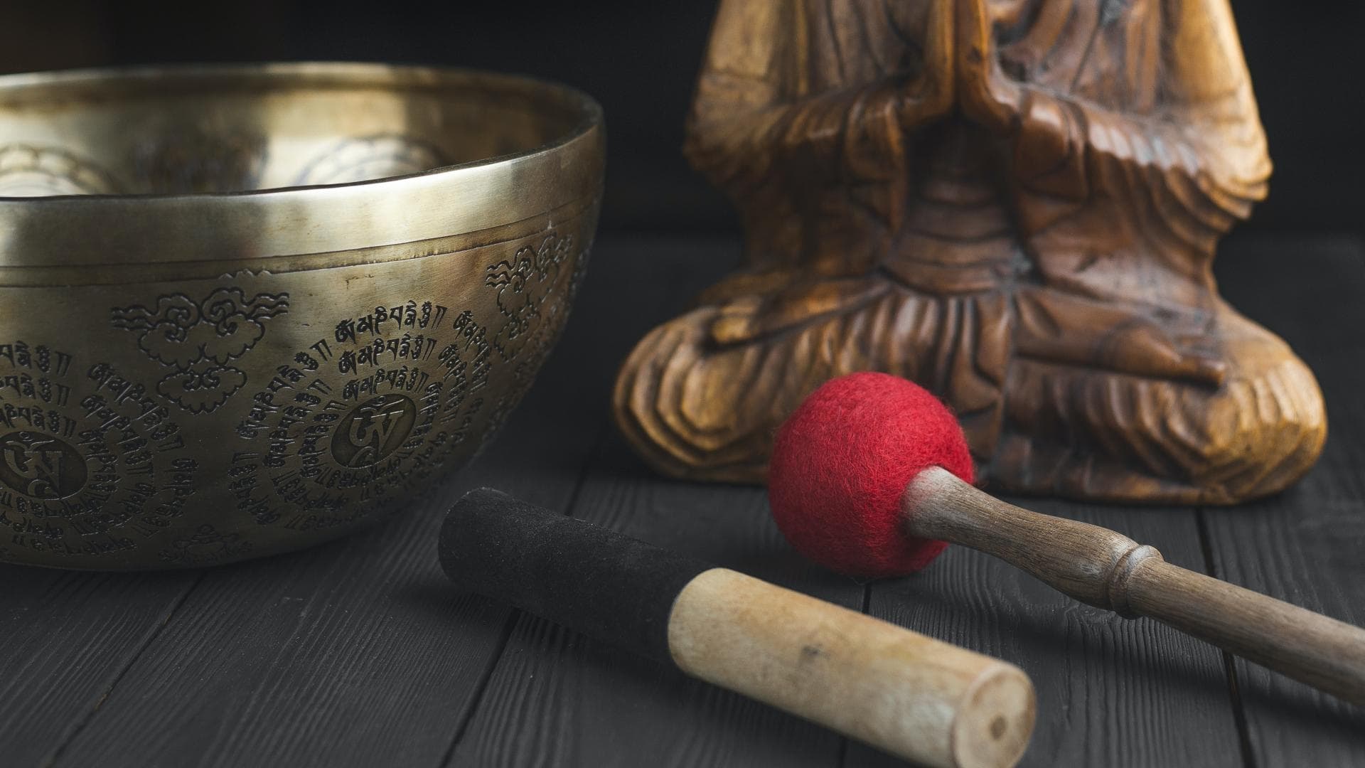 Klangschale mit Schlägel und Buddha-Statue