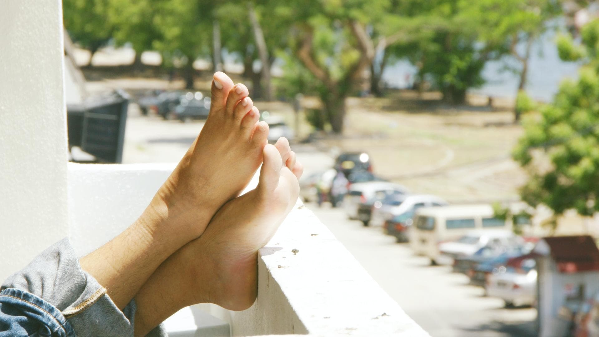 Füße auf Balkon hochgelegt