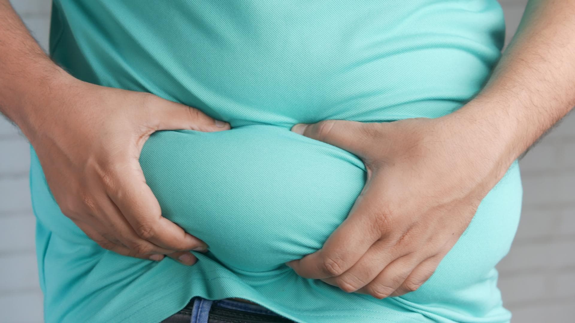 Mann greift sich an den dicken Bauch