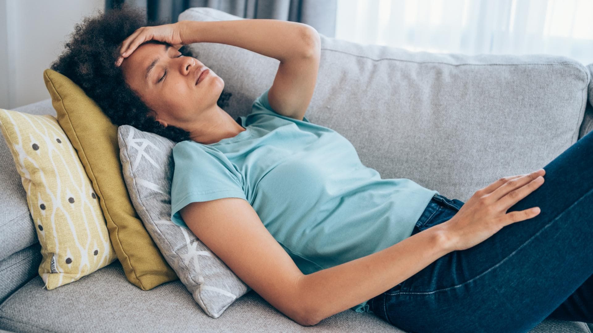 Frau mit Schwindel liegt auf Couch