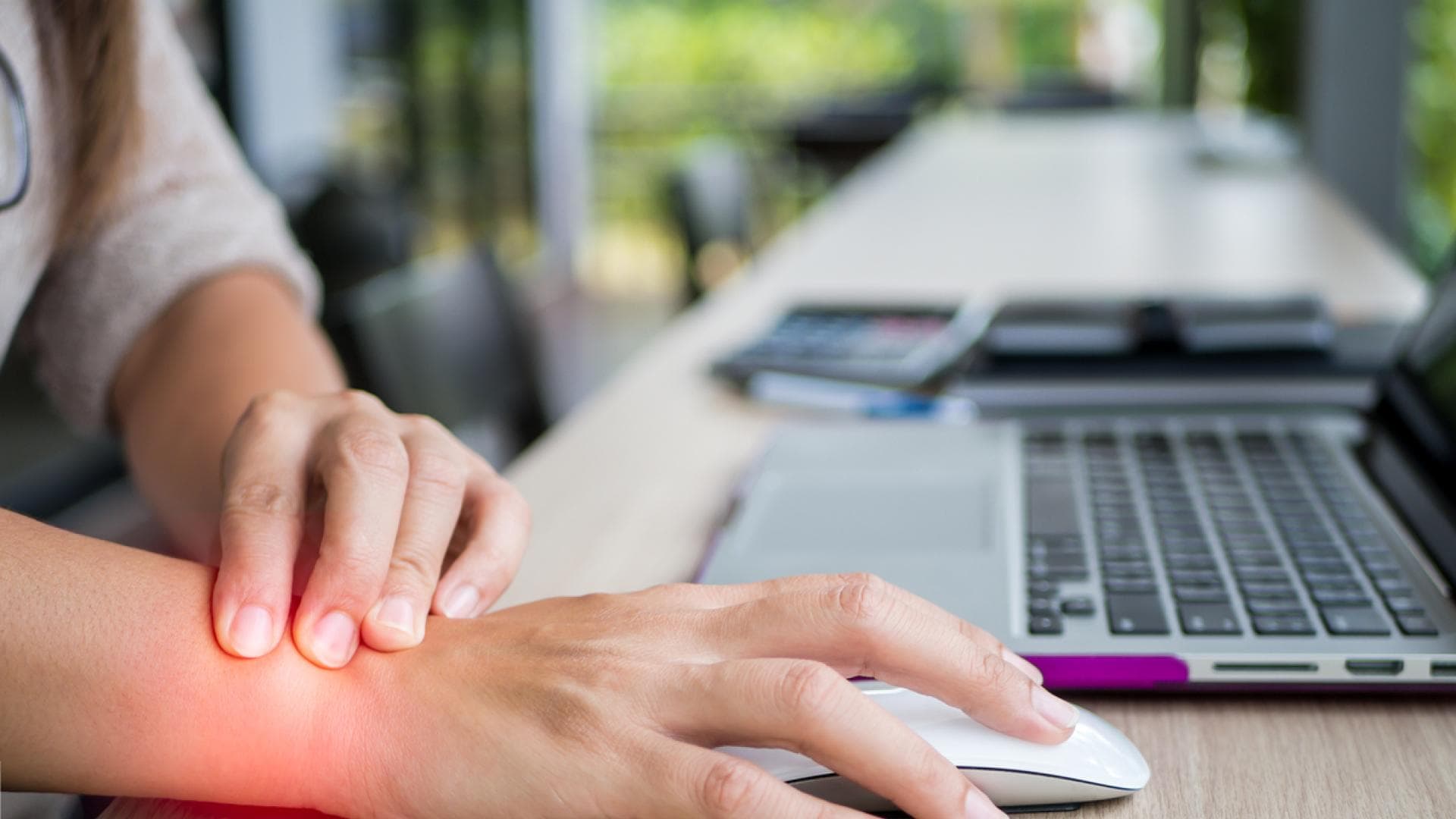 Fehlhaltung führt zu Sehnenscheidenentzündung Frau im Büro mit Schmerz im Handgelenk