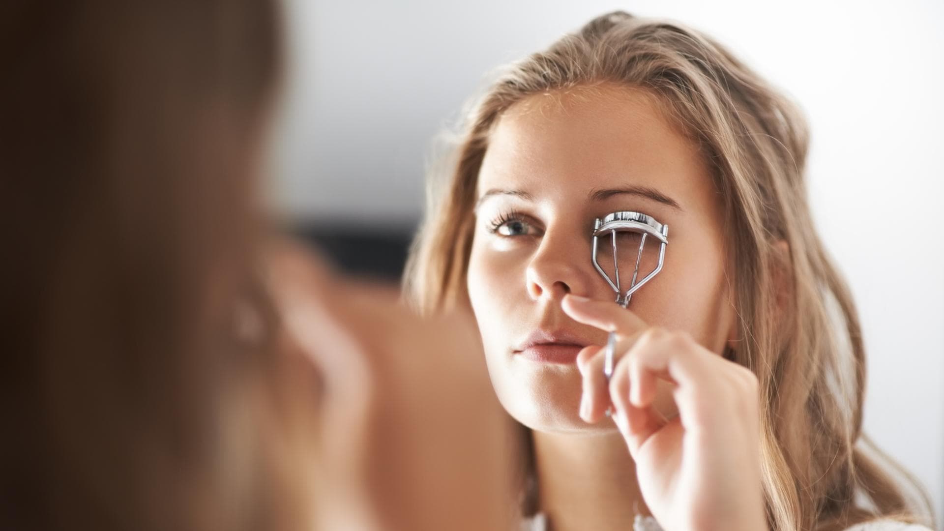 Frau benutzt Wimpernzange Frau benutzt Wimpernzange