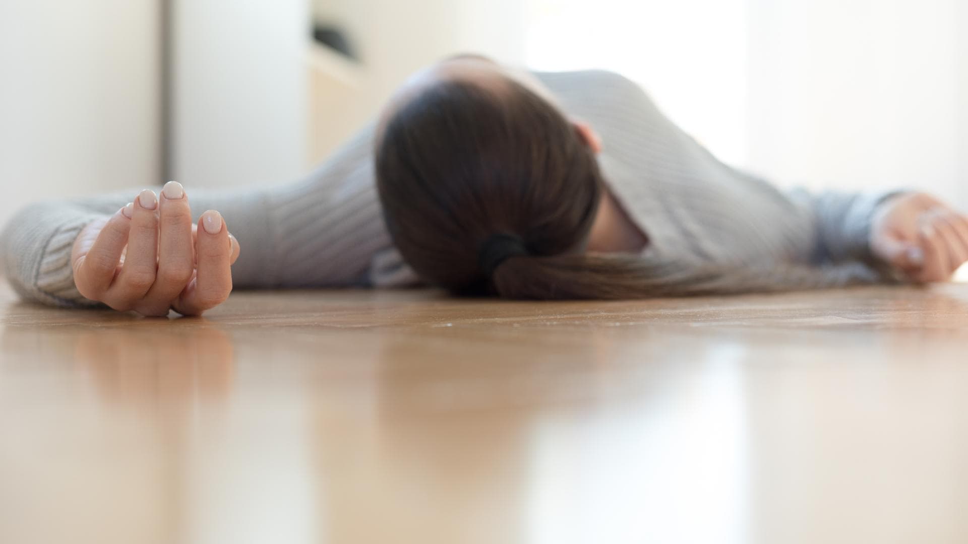 Frau liegt ohnmächtig auf dem Boden