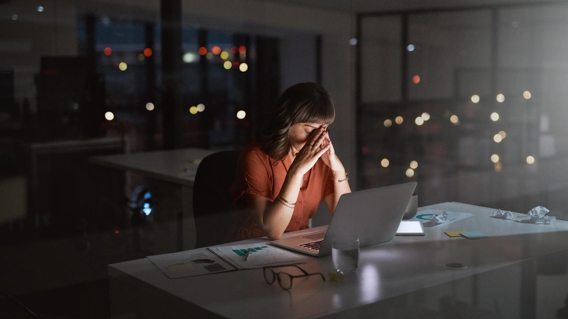 Gestresste Frau, die nachts im Büro arbeitet Gestresste Frau, die nachts im Büro arbeitet