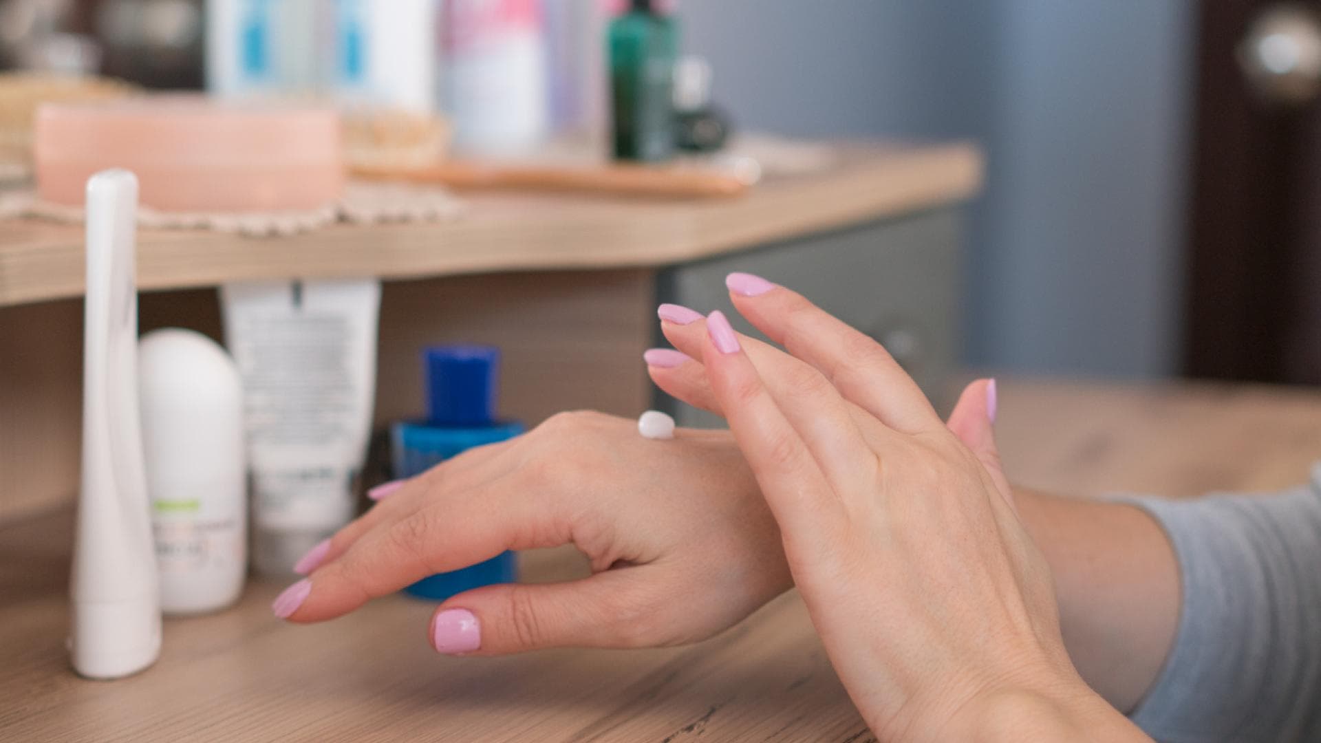 Frau trägt Salbe auf Ekzem auf Hand auf