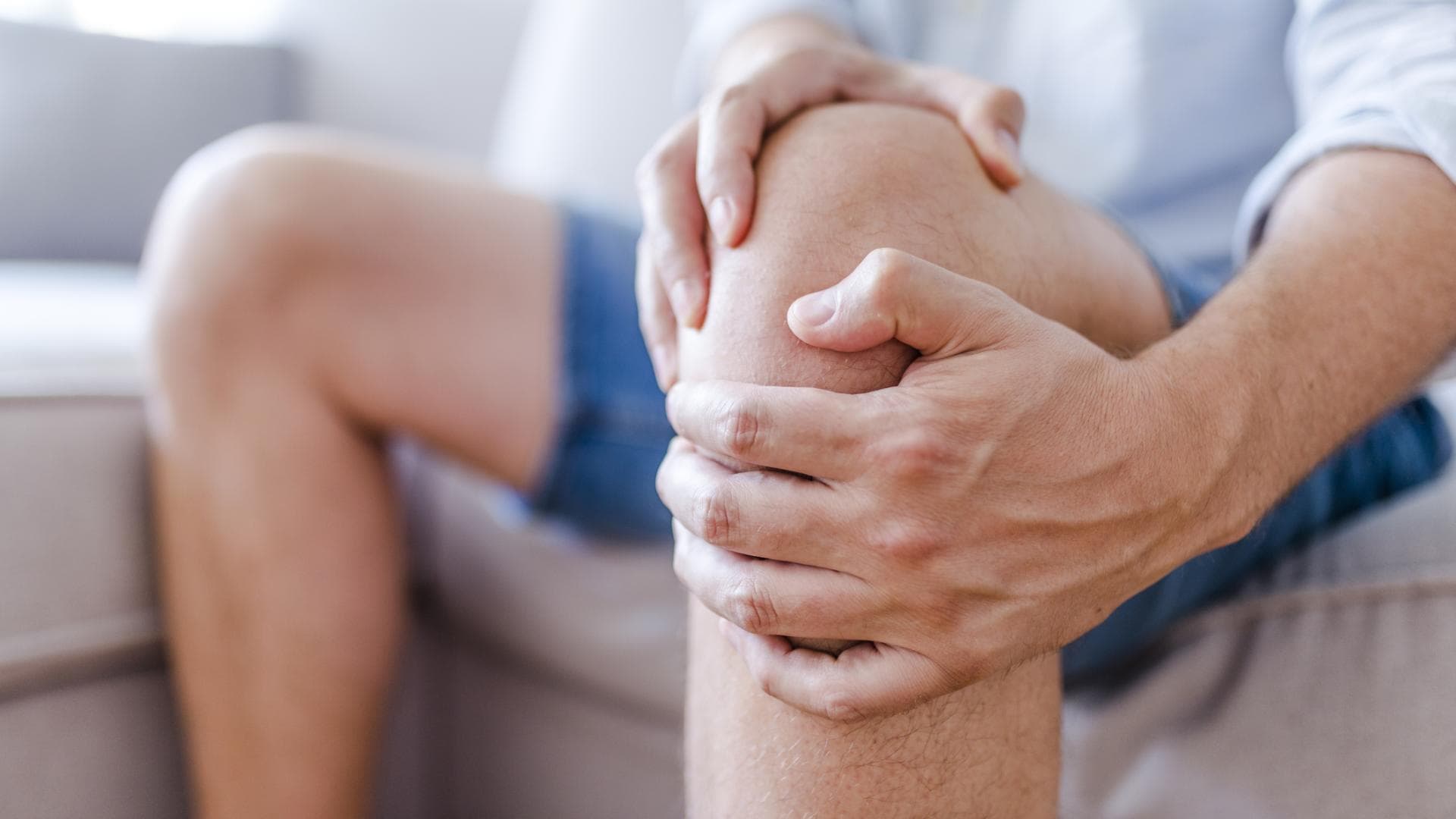 Mann hat Schmerzen im Knie
