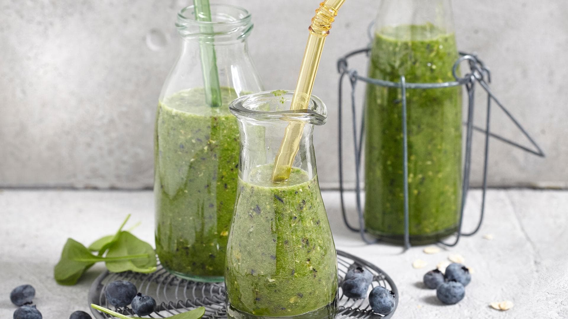 Smoothies mit Spinat haben eine herbe Geschmacknote Spinat-Beeren-Smoothie in Glasflasche