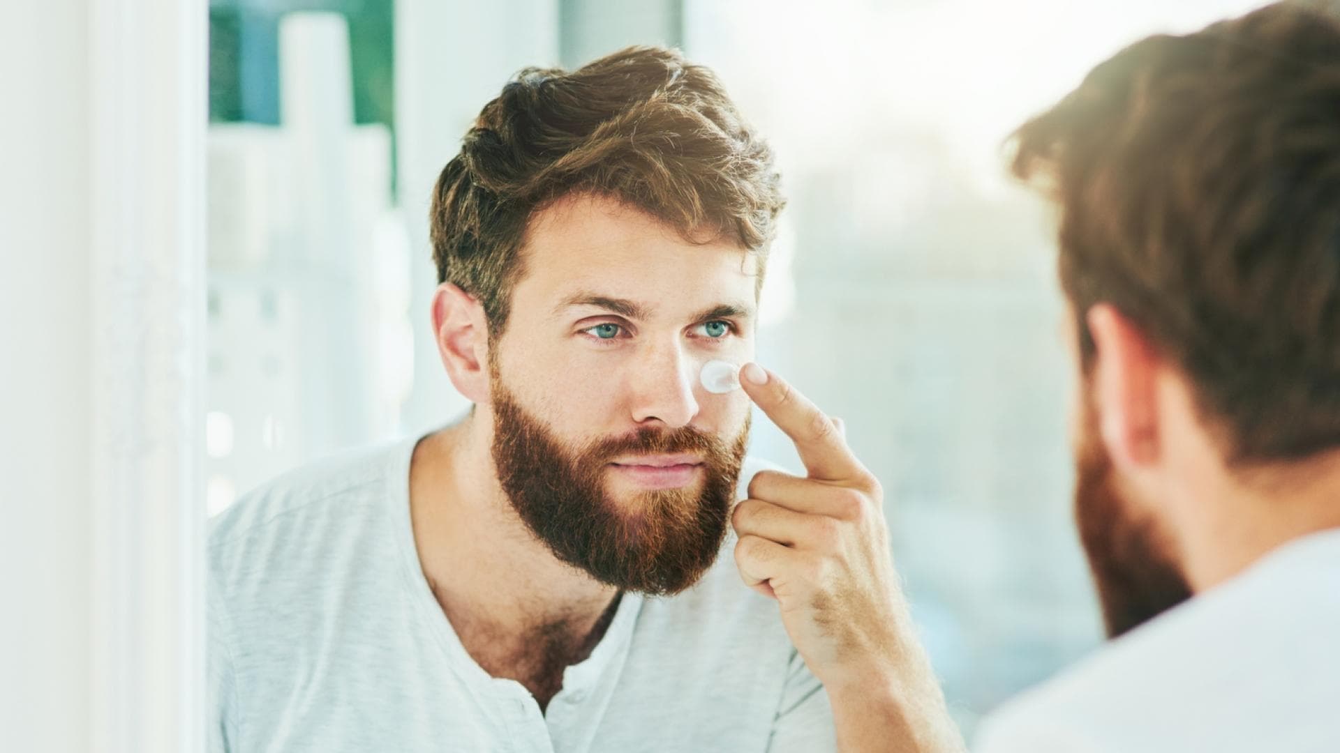 Gesichtspflege für Männer Mann pflegt Gesicht mit Creme