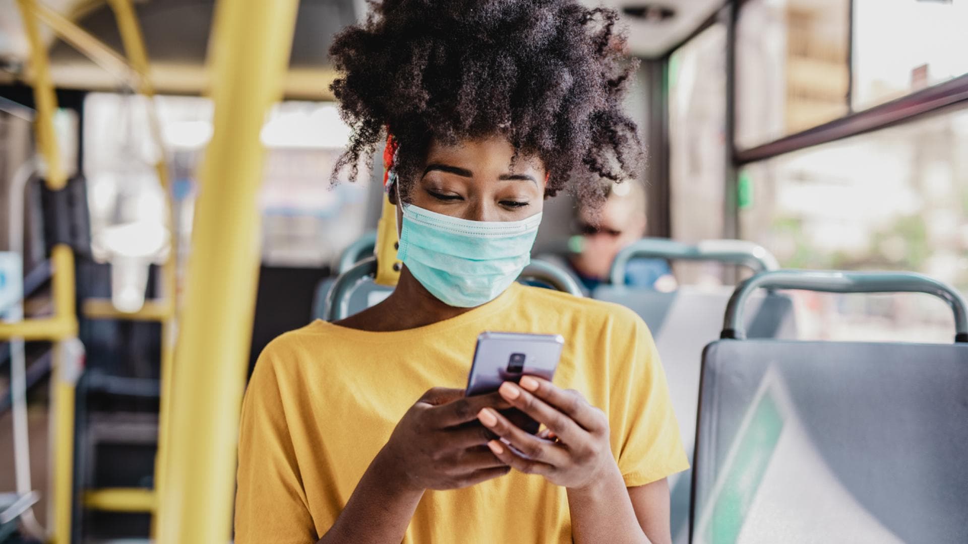 Masketragen schützt auch vor Sommergrippe Frau trägt Maske im Linienbus
