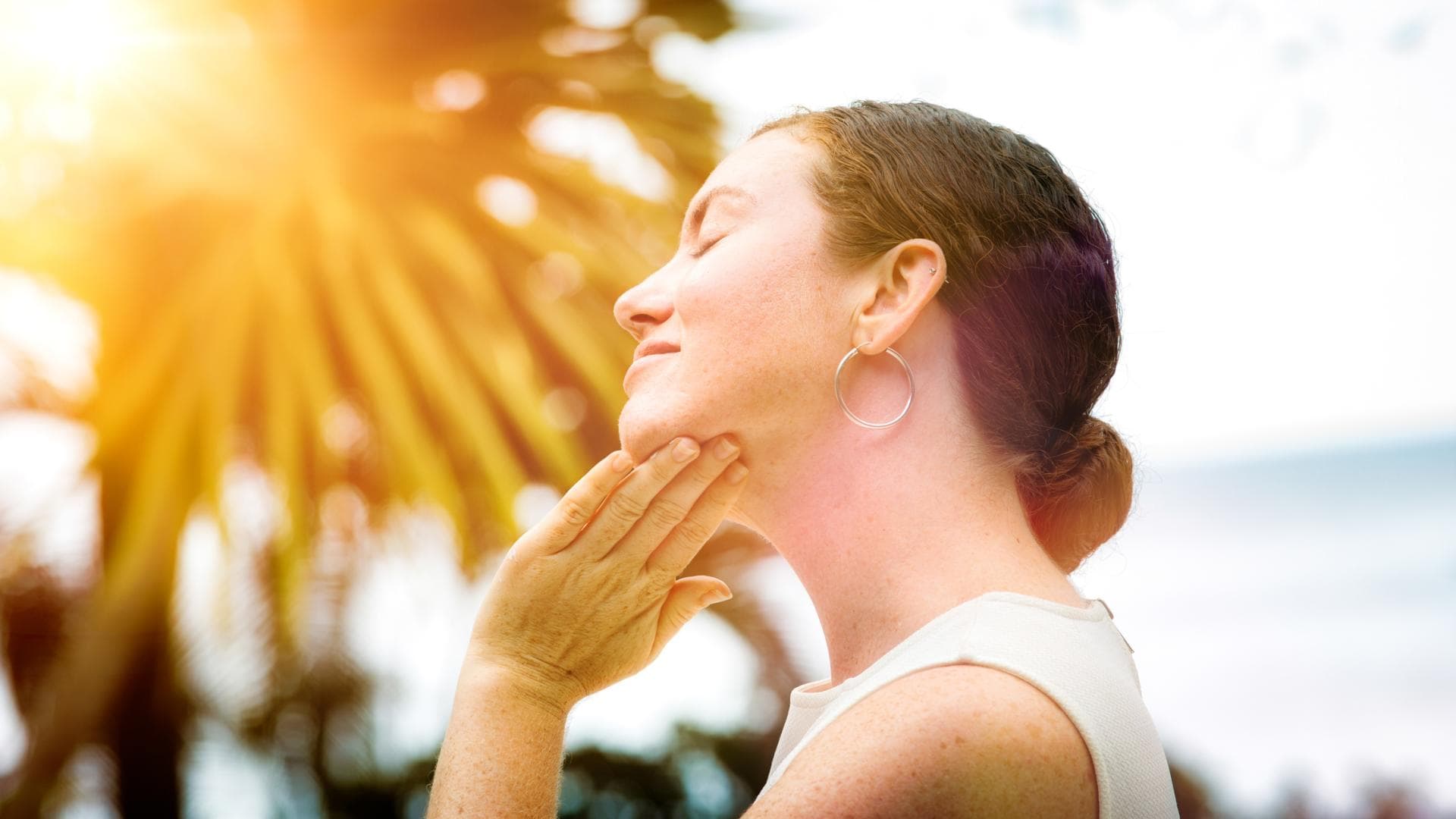 Frau cremt sich Gesicht mit Sonnencreme ein Frau Gesicht Sonnencreme