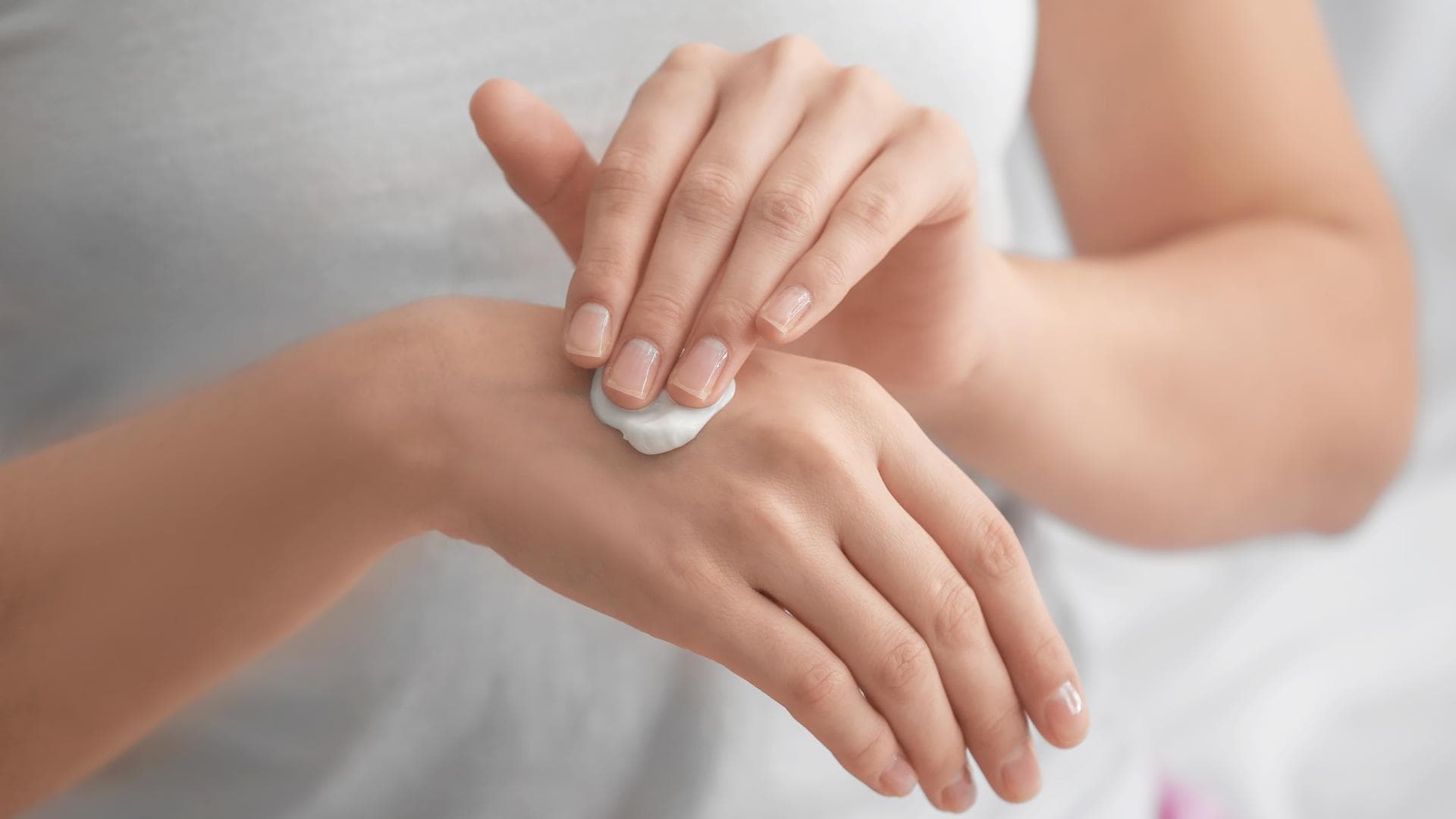 F>rau trägt Handlotion auf