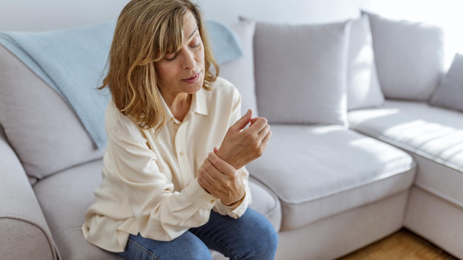 Frau hält sich schmerzendes Handgelenk