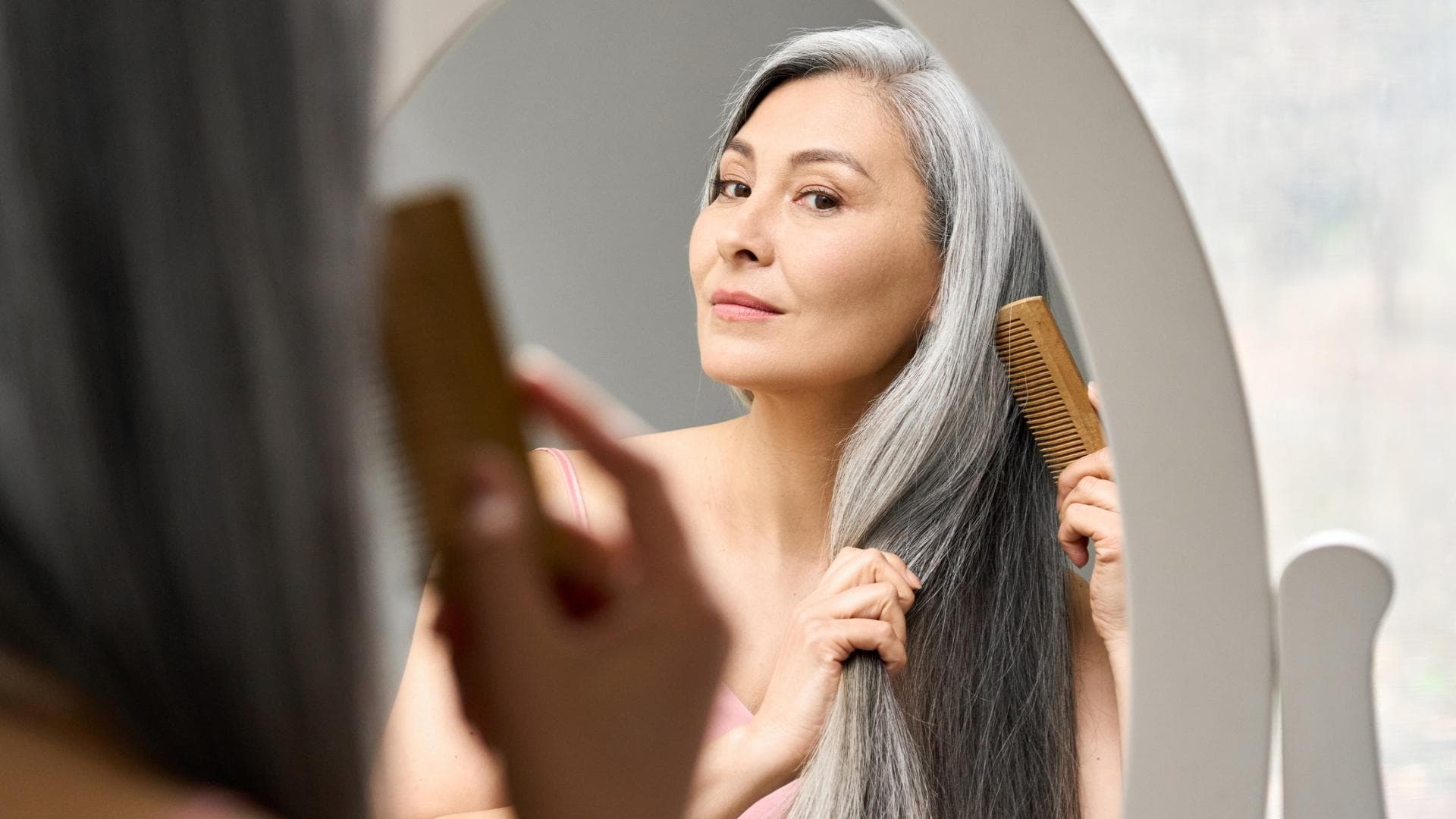 Frau kämmt graue Haare