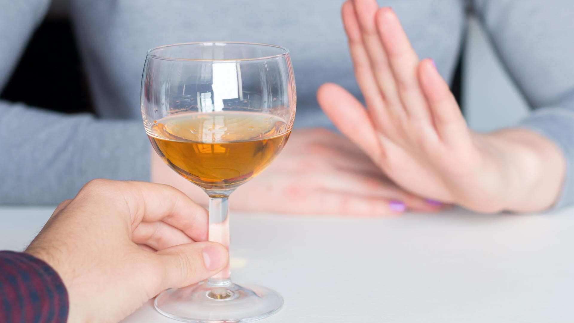 Alkoholverzicht Frau lehnt mit Handgeste ein Glas Wein ab