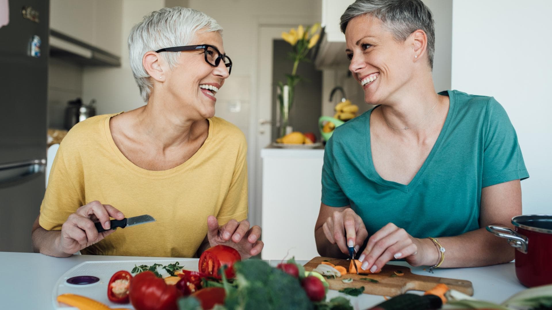 zwei reife Frauen bereiten Lebensmittel in Küche vor